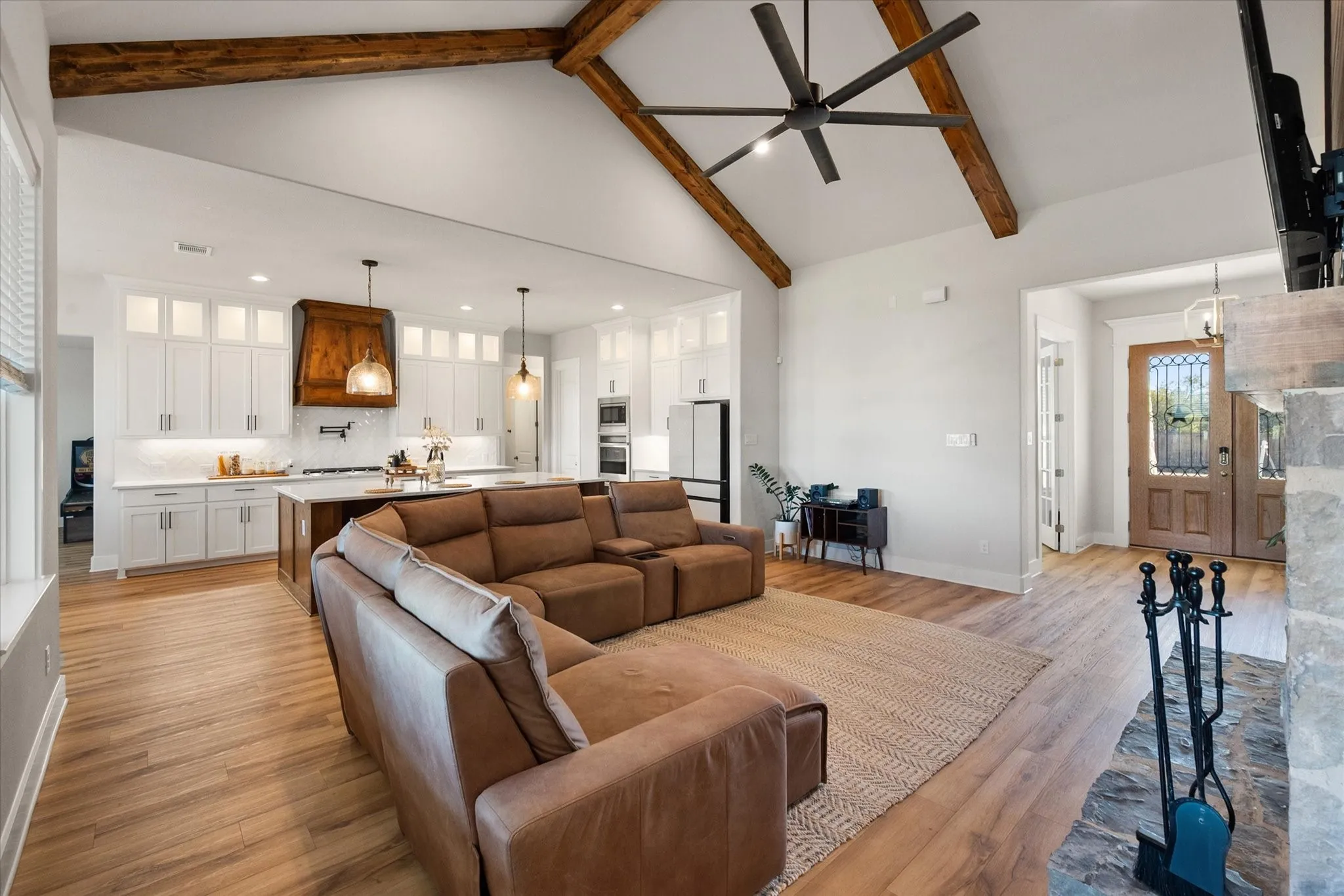 Living area featuring high vaulted ceiling, light wood-type flooring, beam ceiling, ceiling fan, and recessed lighting