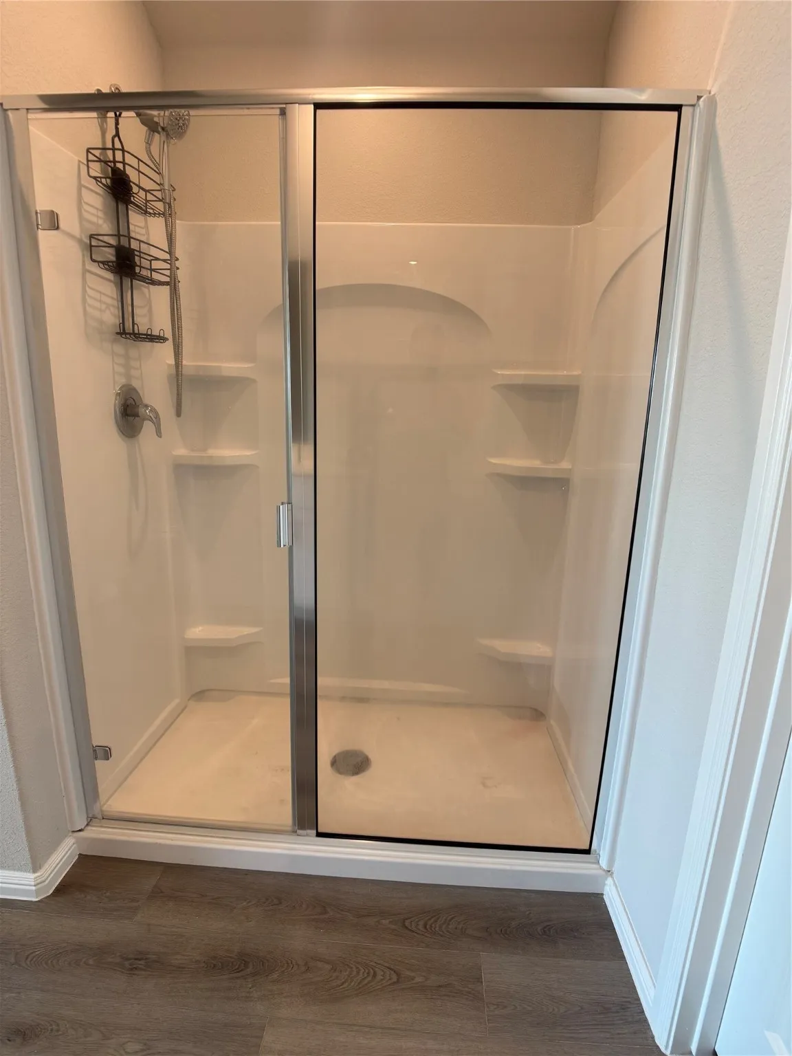 Full bath with dark wood-type flooring and a shower stall