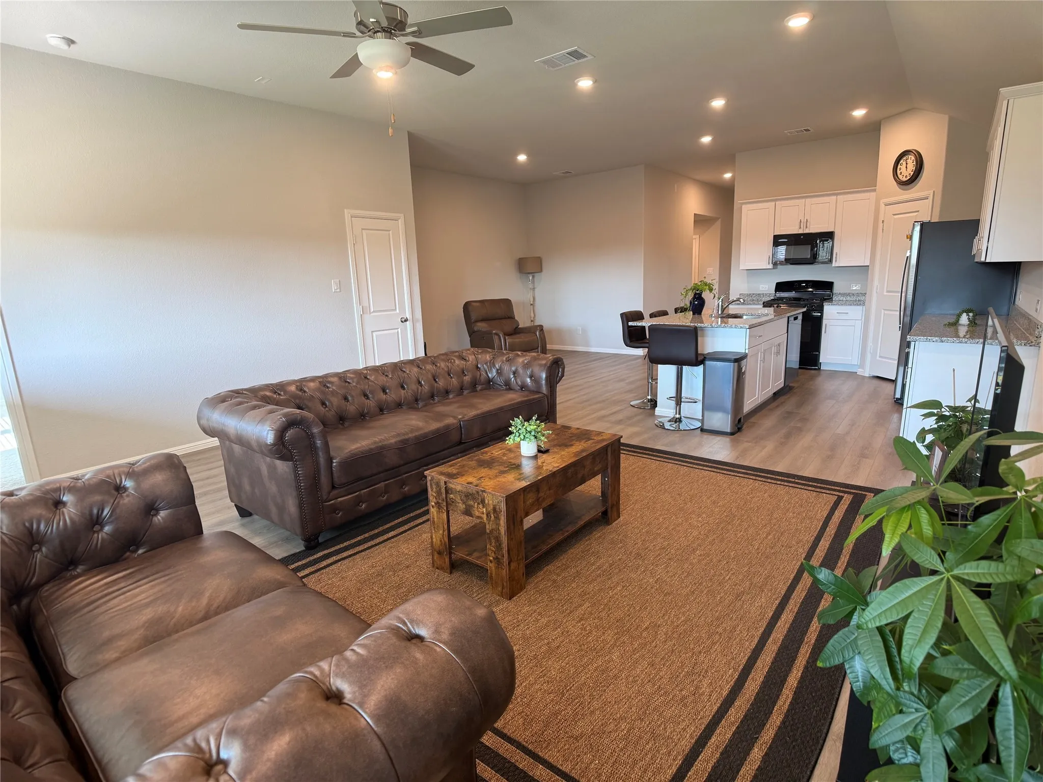 Living room with light wood-style flooring, recessed lighting, and ceiling fan