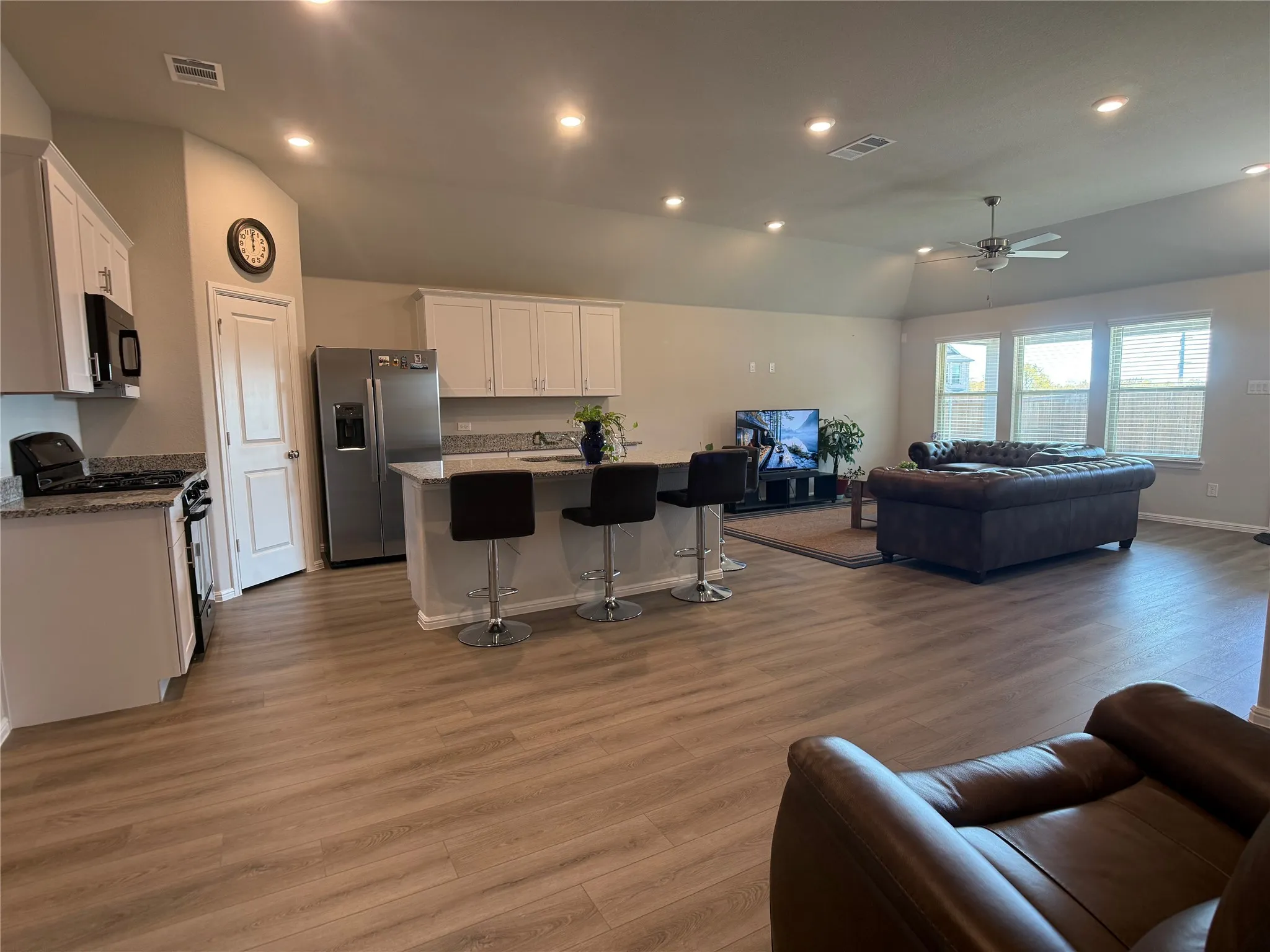 Living room featuring recessed lighting, light wood-style floors, lofted ceiling, and a ceiling fan