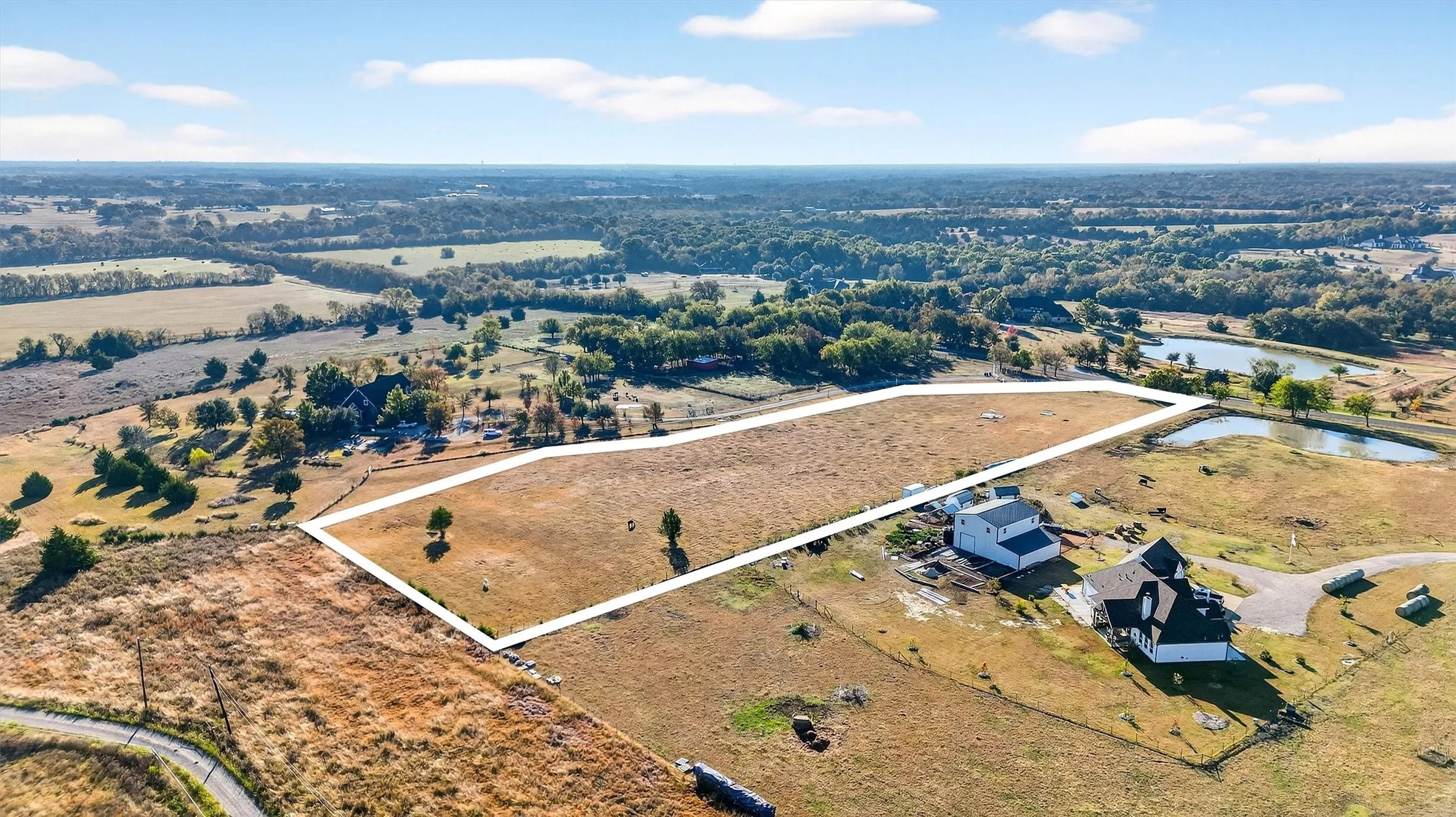 Aerial view of property and surrounding area featuring property boundaries highlighted and a large body of water