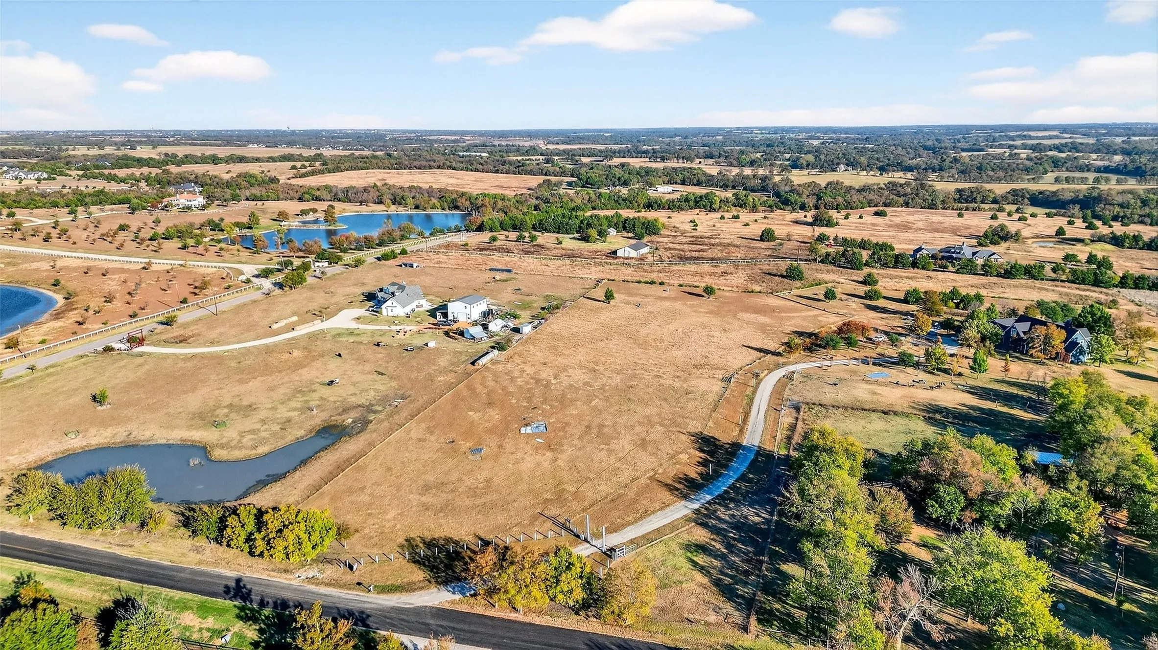 Aerial view of property and surrounding area featuring a nearby body of water and rural landscape