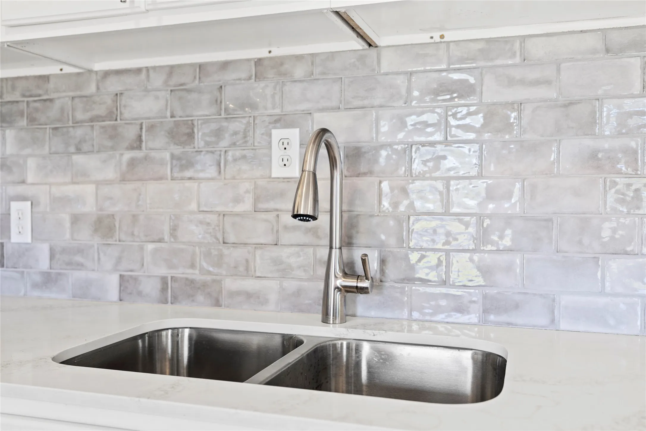 Kitchen view of light  countertops and decorative backsplash