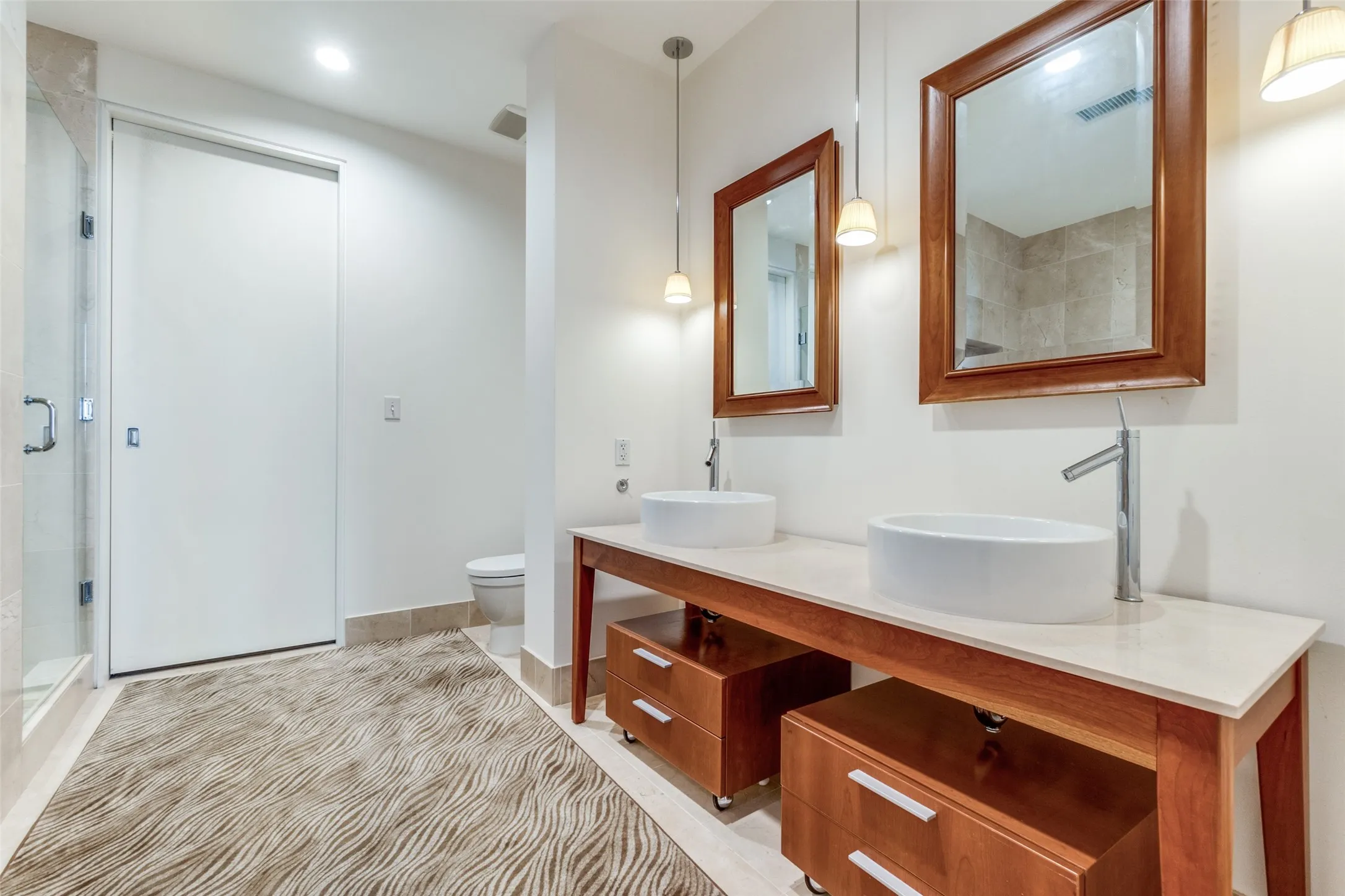 Full bathroom featuring double vanity and a shower stall