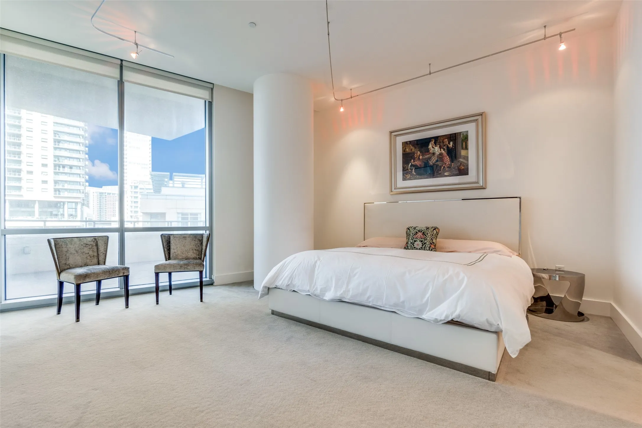 Bedroom with expansive windows, carpet flooring, and track lighting