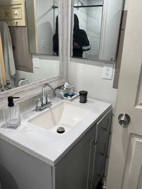 Bathroom featuring vanity and a textured wall
