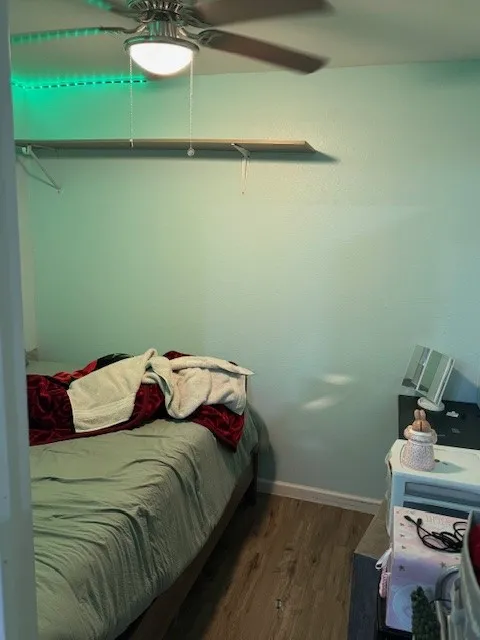 Bedroom featuring dark wood-style floors and a ceiling fan