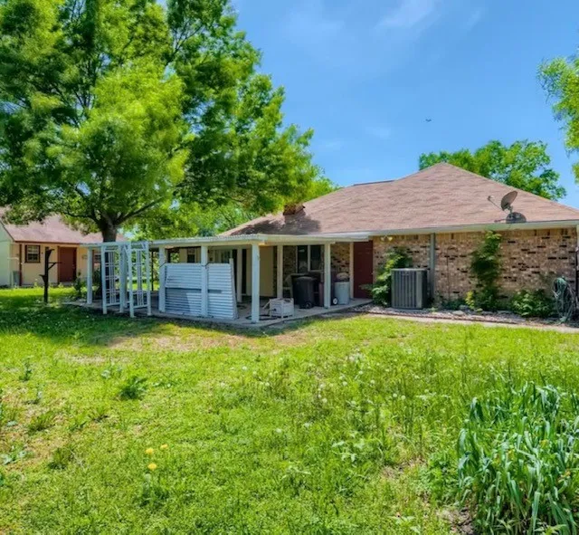 View of front of home featuring a patio, a front yard, and brick siding