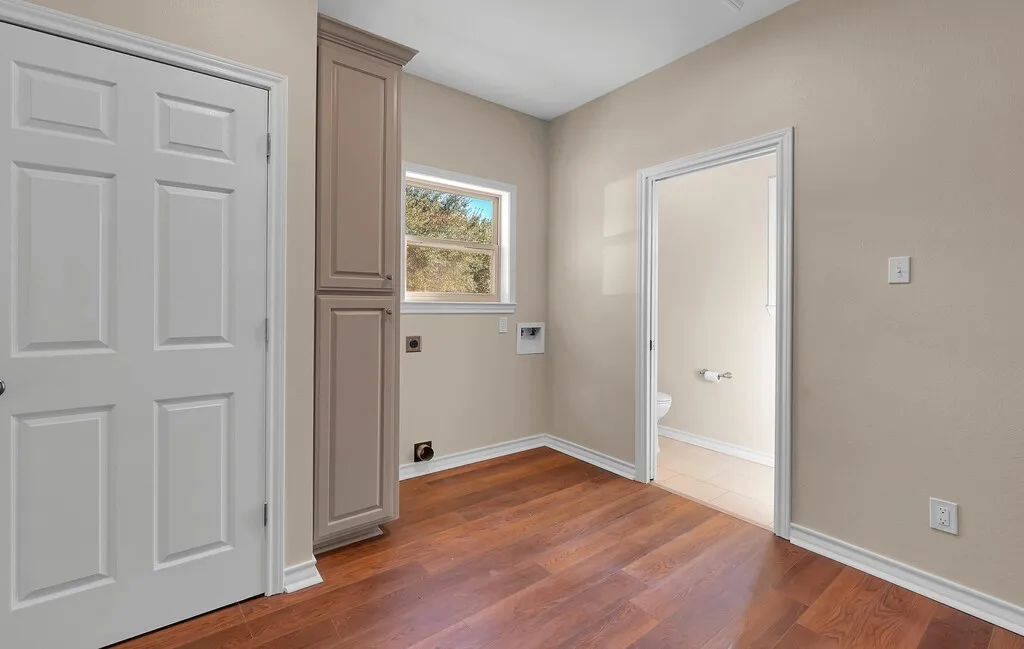 Laundry room featuring cabinet space, dark wood-style floors, hookup for an electric dryer, and hookup for a washing machine