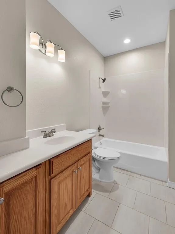 Full bathroom with vanity, light tile patterned floors, shower / washtub combination, and recessed lighting