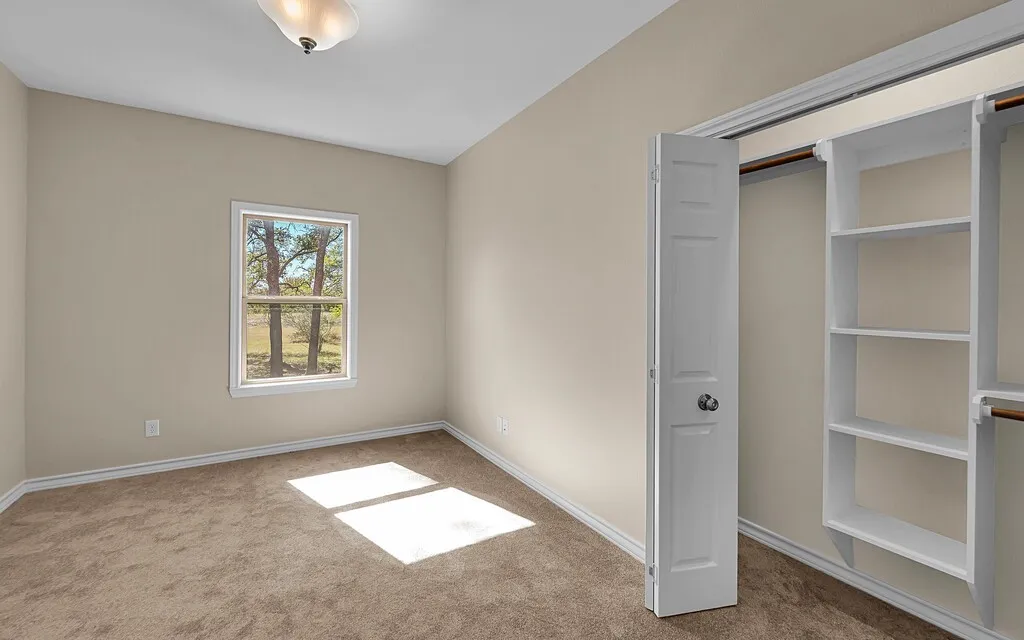 Unfurnished bedroom with carpet flooring