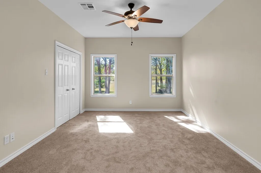 Unfurnished bedroom featuring carpet floors, a closet, and ceiling fan
