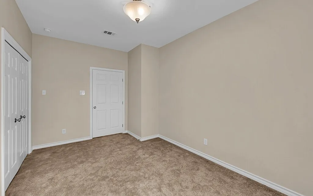 Unfurnished bedroom with light colored carpet and a closet