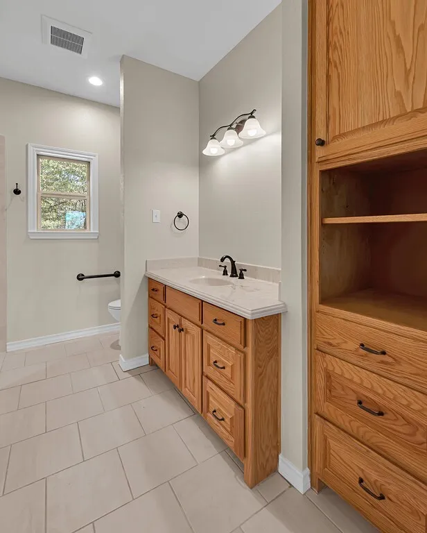 Bathroom with light tile patterned floors, vanity, and recessed lighting