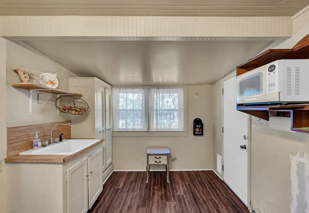 Washroom with dark wood-style floors and a sink