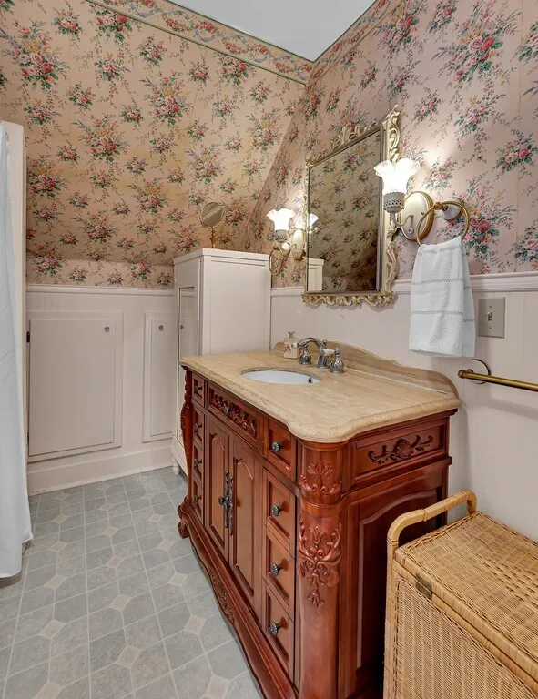 Bathroom with a wainscoted wall, vanity, wallpapered walls, and light tile patterned flooring
