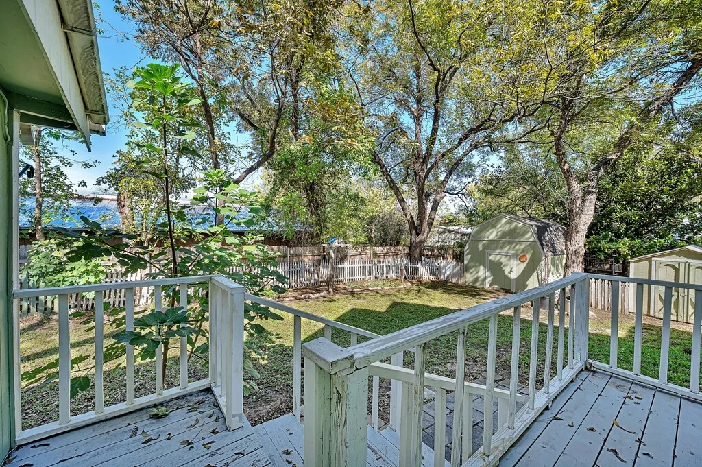 Deck featuring a storage shed and a fenced backyard