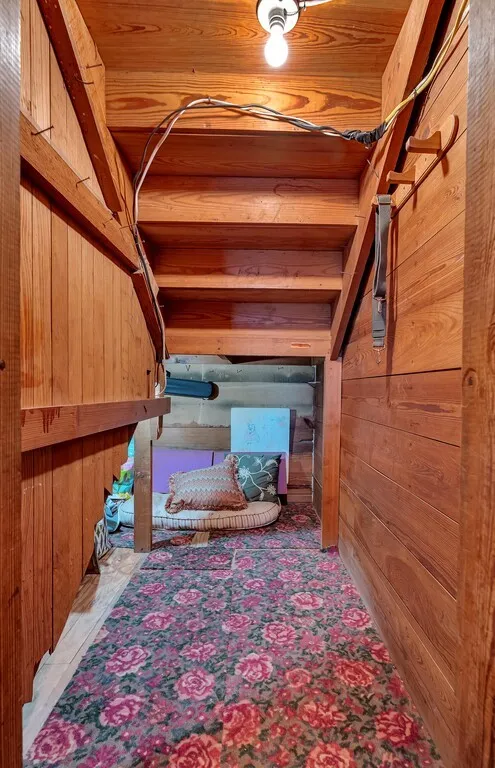 Bedroom view of wood walls and wood ceiling