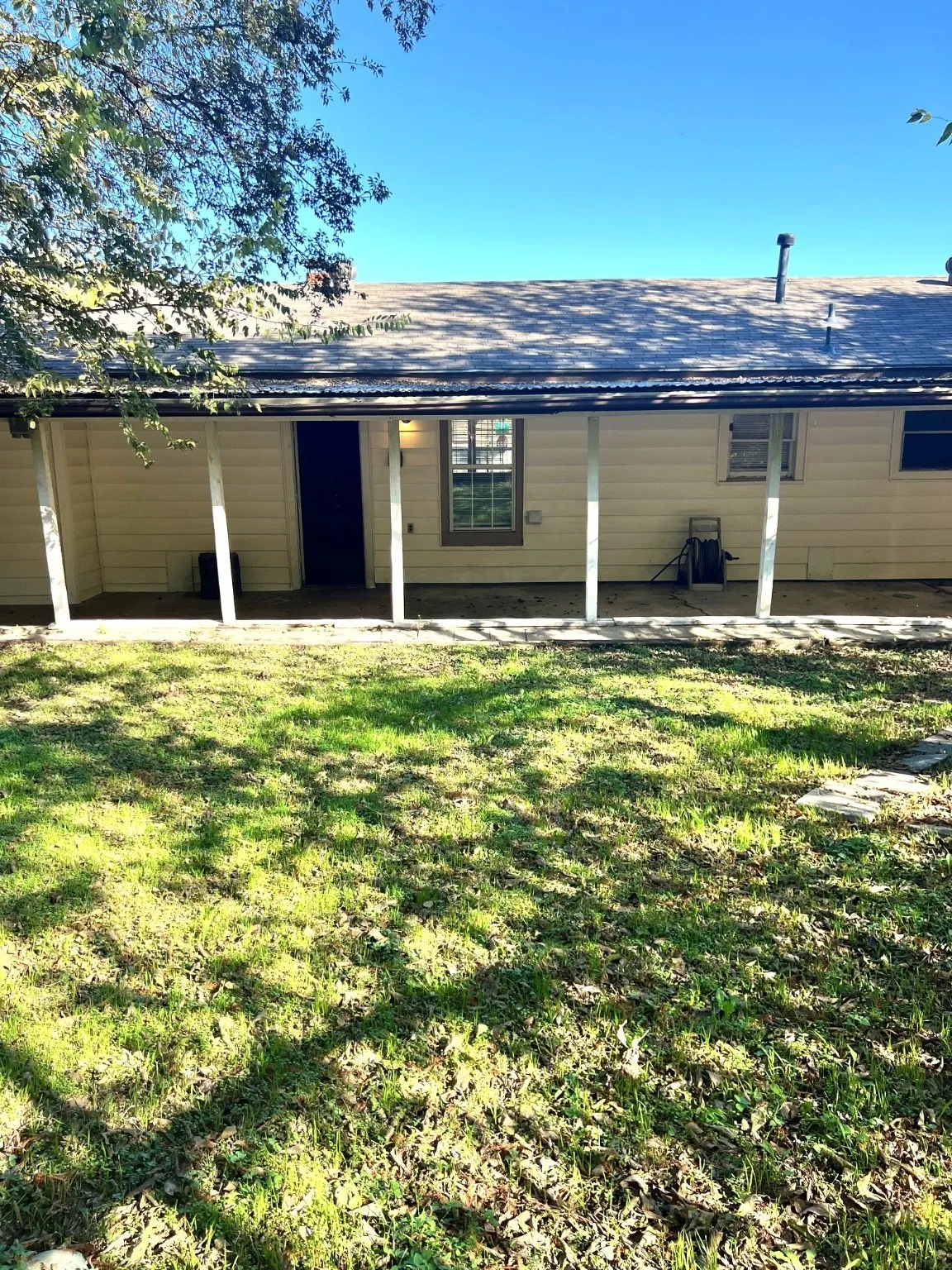 Rear view of property with a yard and a shingled roof