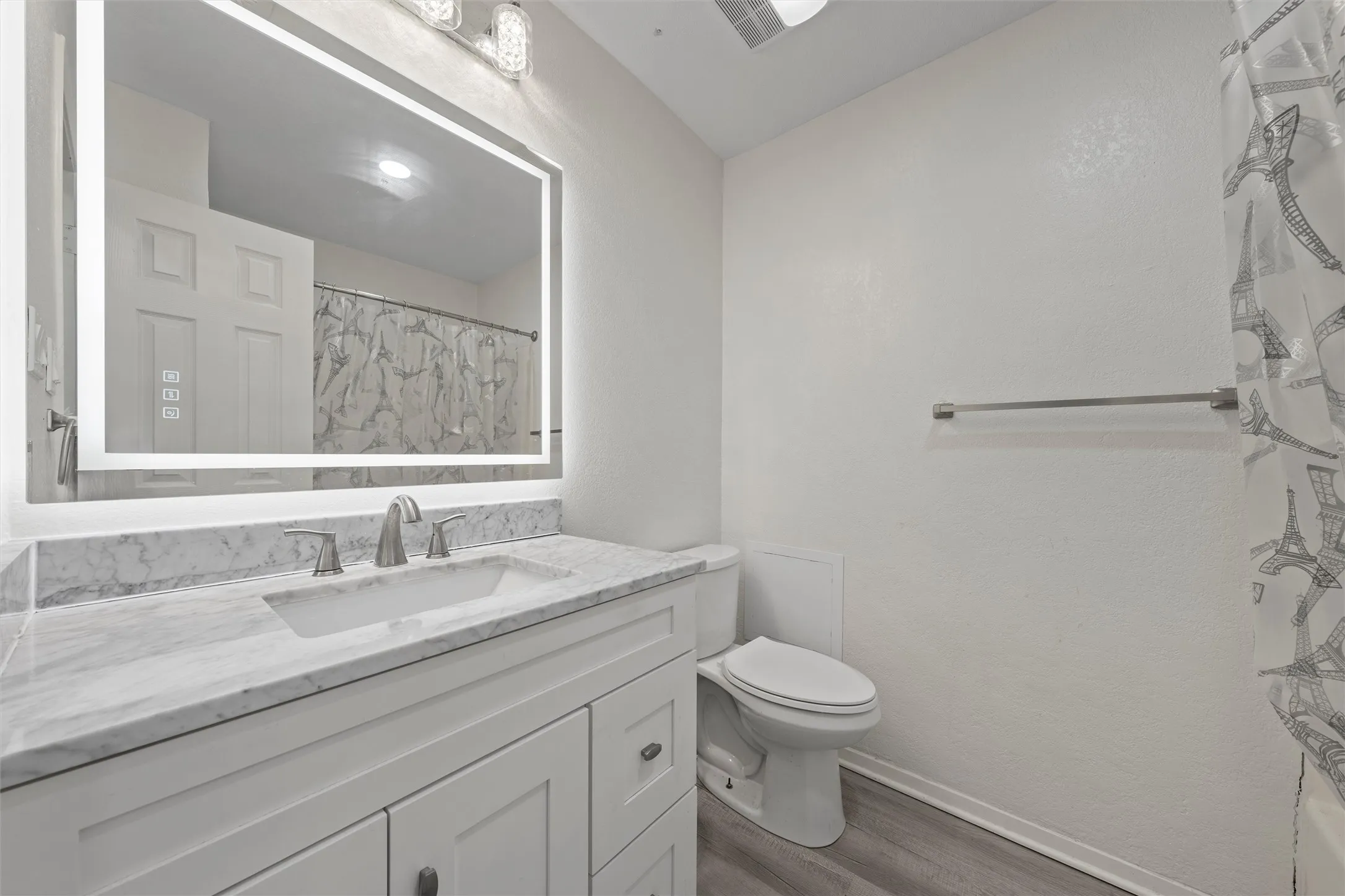 Bathroom with curtained shower, dark wood finished floors, and vanity