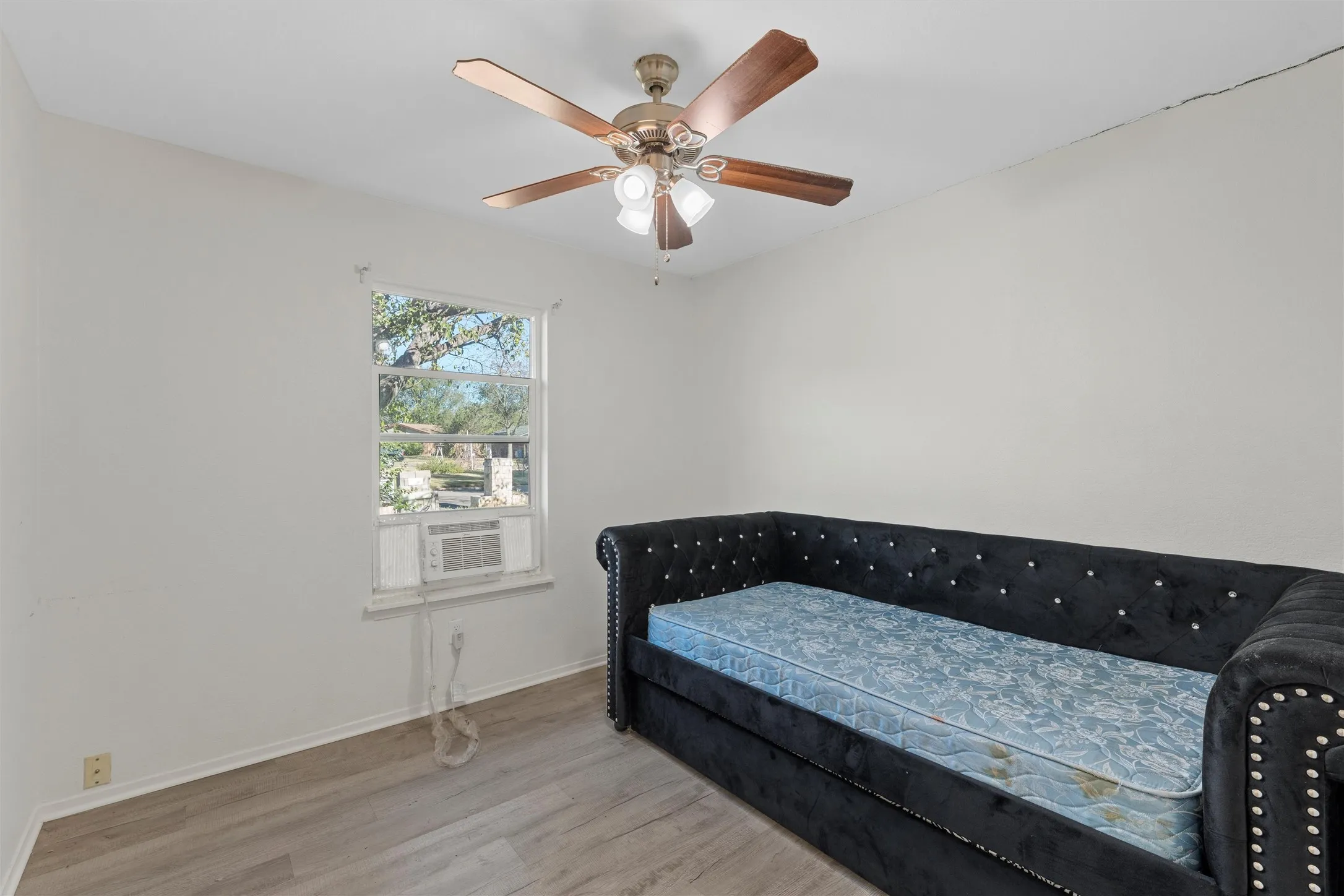 Bedroom featuring wood finished floors, a ceiling fan, and cooling unit