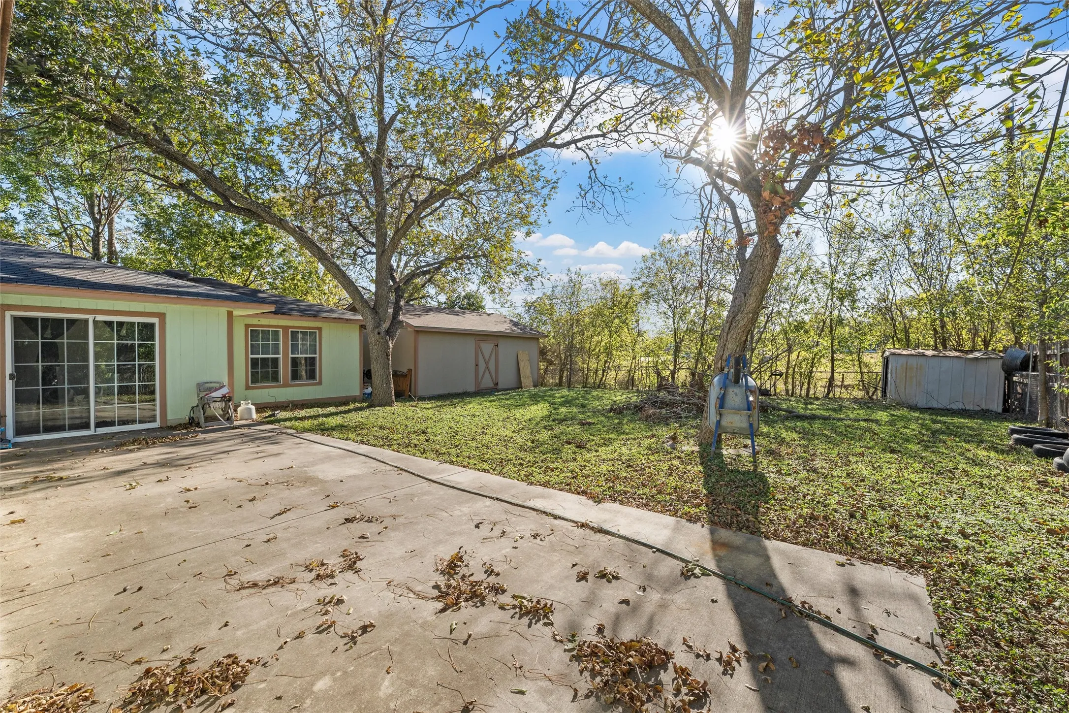 Fenced backyard with a patio and a storage shed