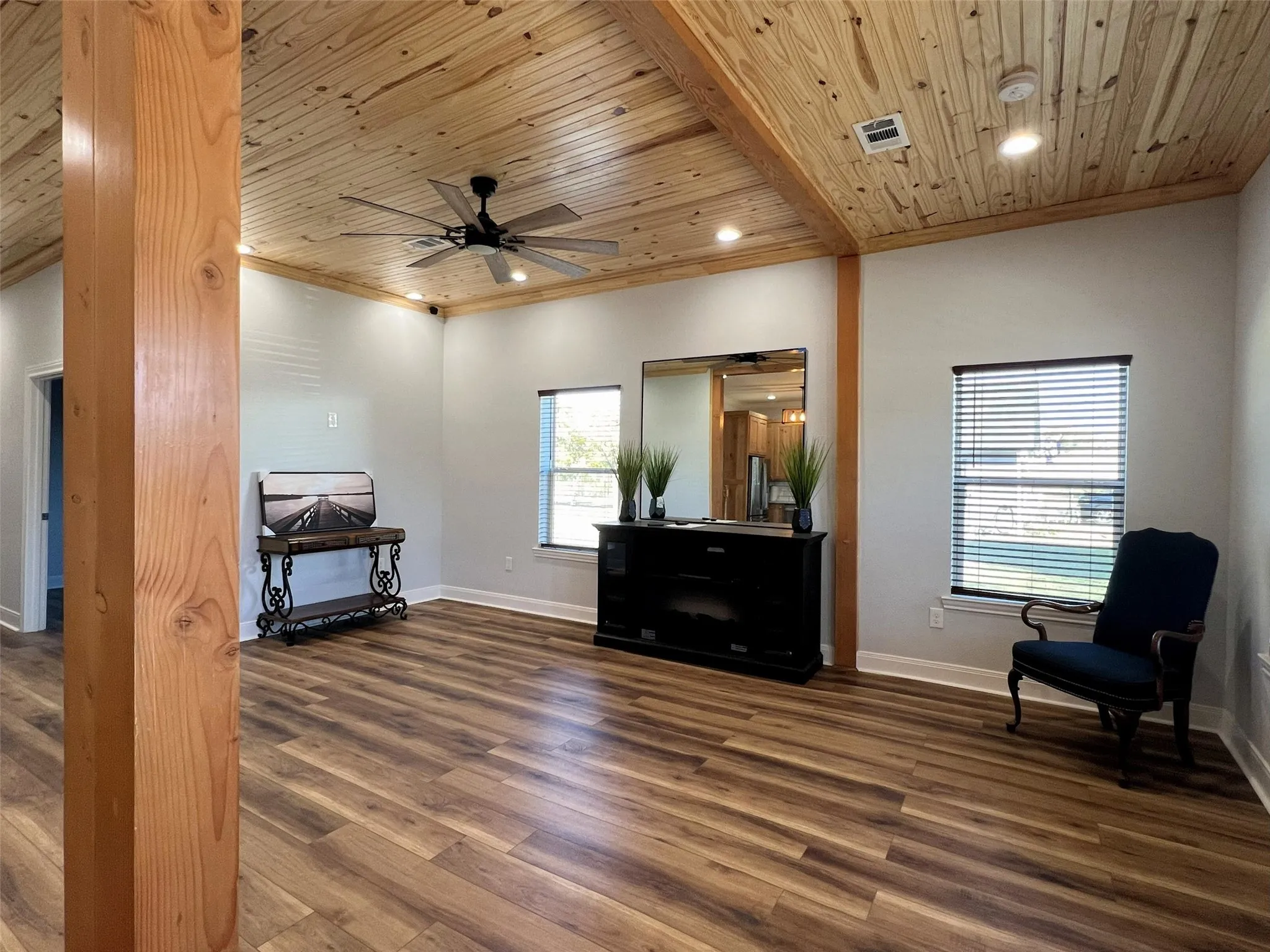 Living area featuring dark wood-style floors, crown molding, recessed lighting, wooden ceiling, and ceiling fan