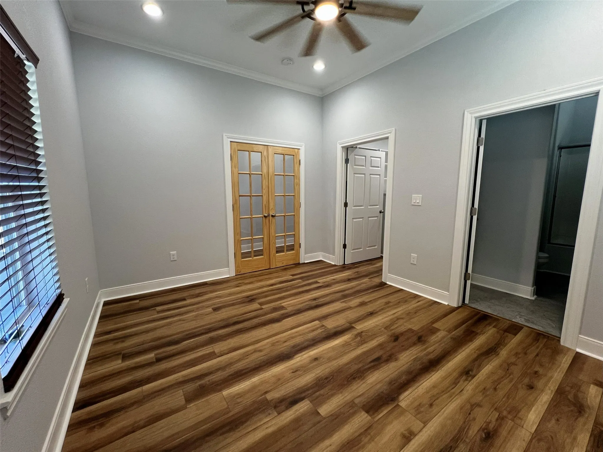 Unfurnished bedroom with crown molding, dark wood-style flooring, french doors, a ceiling fan, and recessed lighting