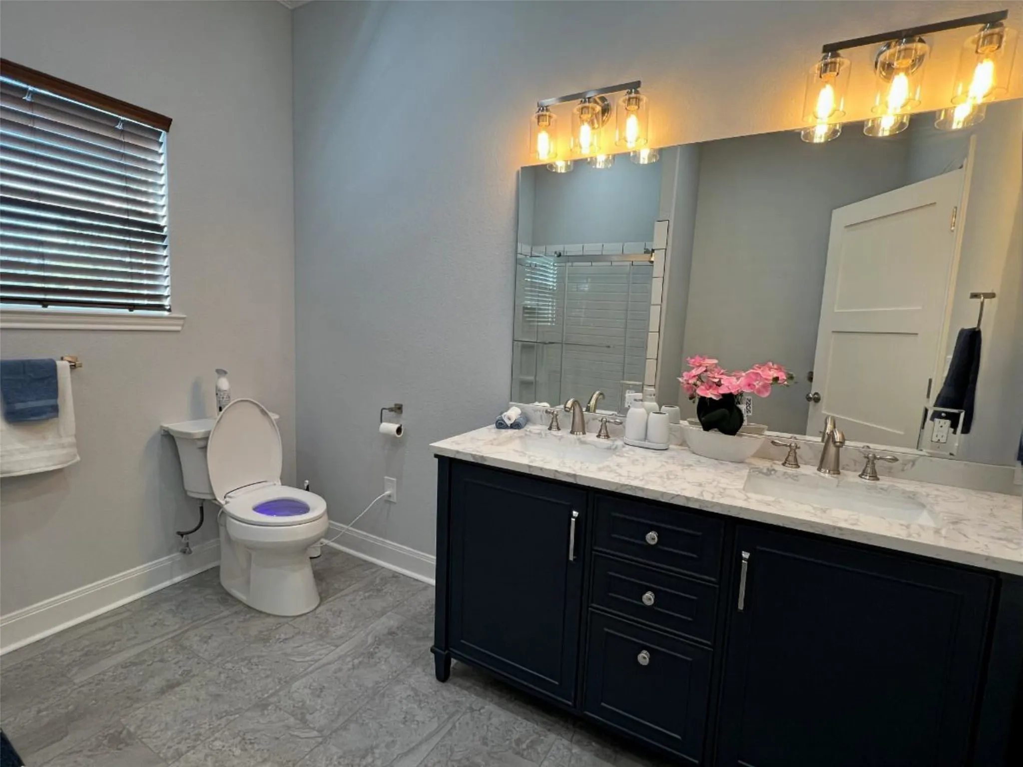 Bathroom featuring a stall shower and double vanity