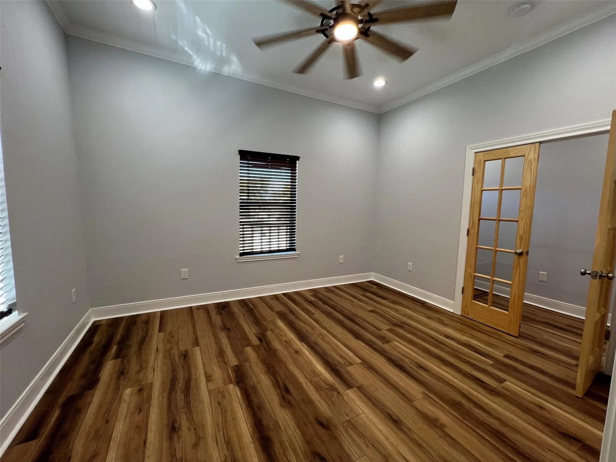 Empty room featuring ornamental molding, dark wood-type flooring, ceiling fan, and recessed lighting