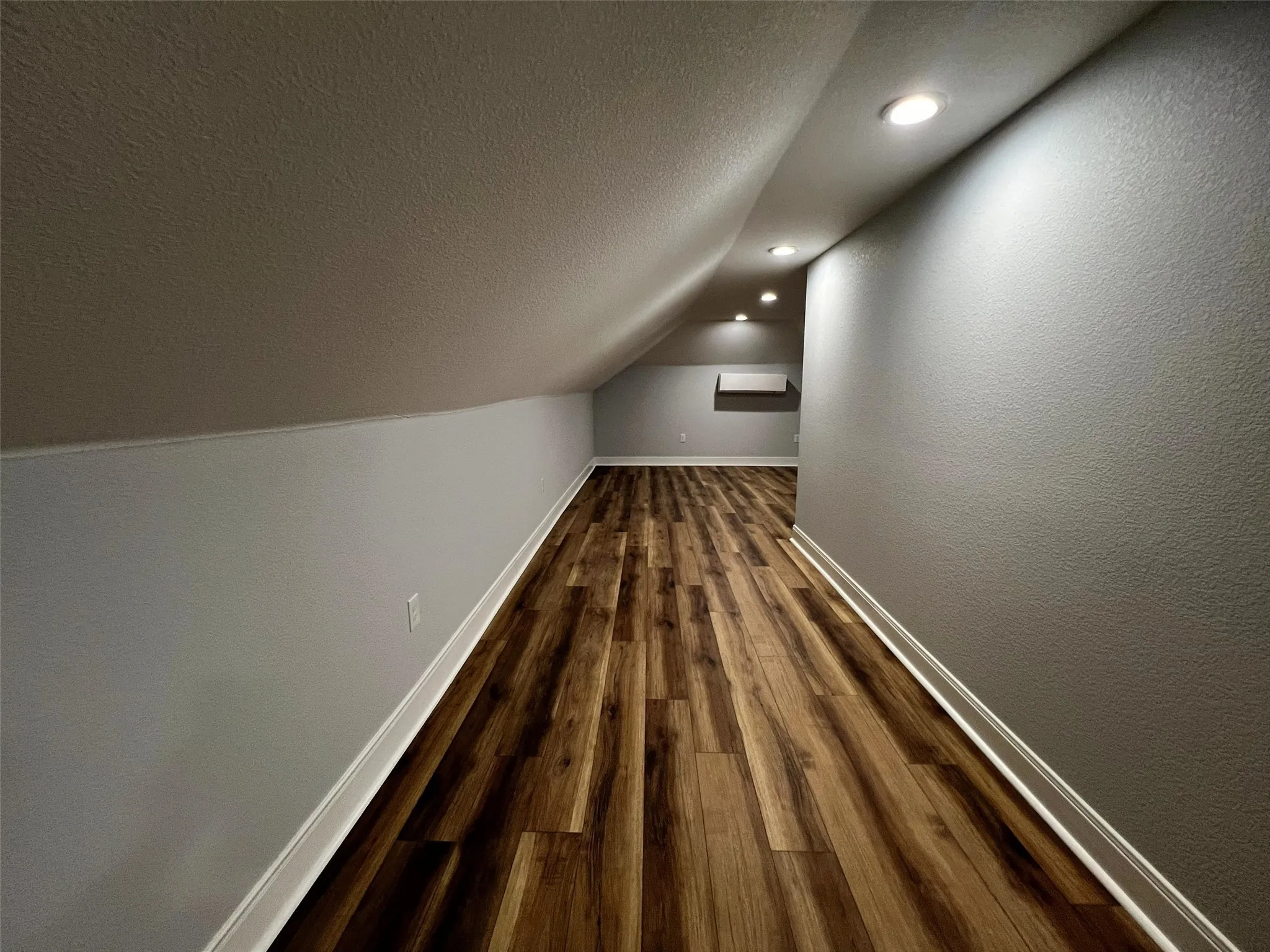 Bonus room with a textured ceiling, dark wood-type flooring, lofted ceiling, and recessed lighting
