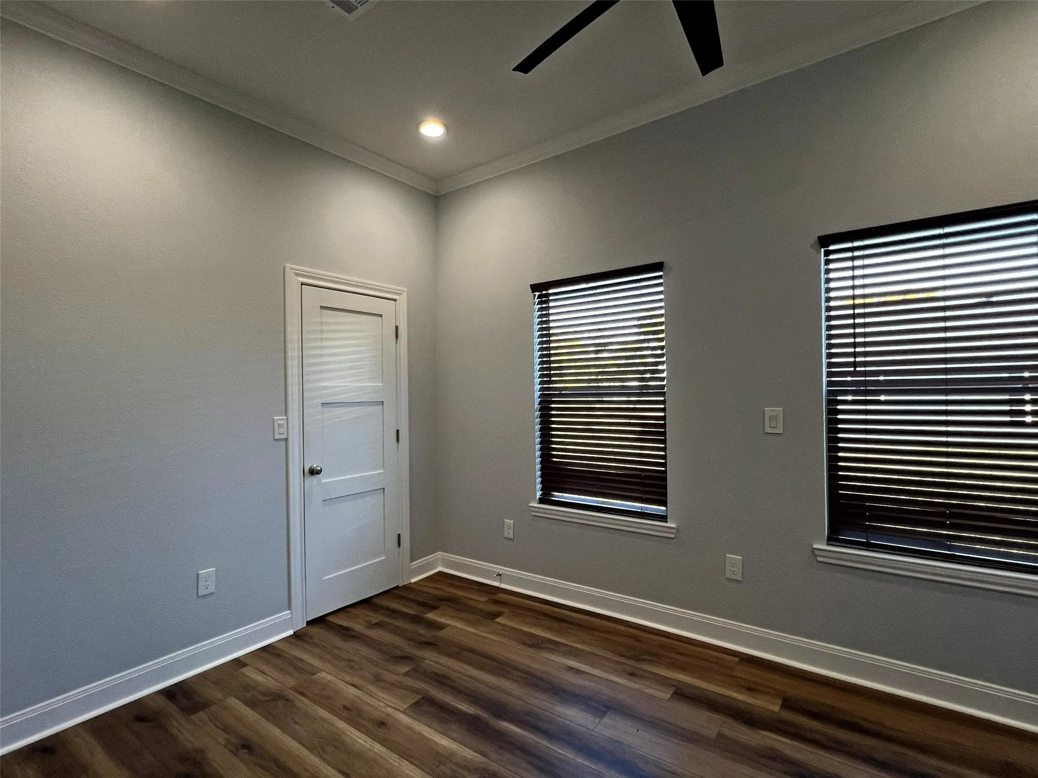 Empty room with ornamental molding, dark wood-style flooring, a ceiling fan, and recessed lighting