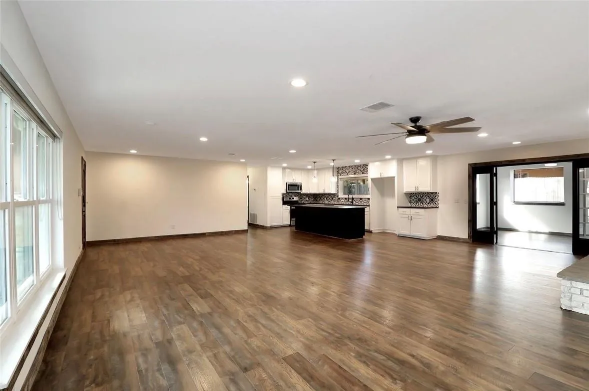 Unfurnished living room with a baseboard heating unit, dark wood-type flooring, recessed lighting, and a ceiling fan