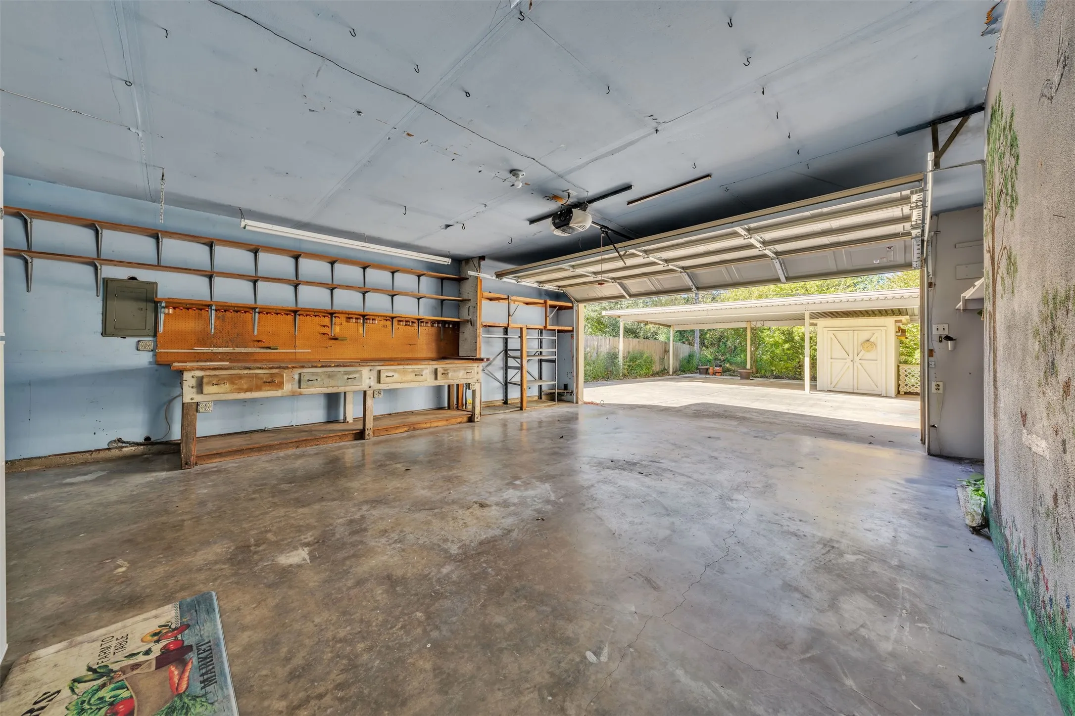 Garage featuring electric panel and a garage door opener