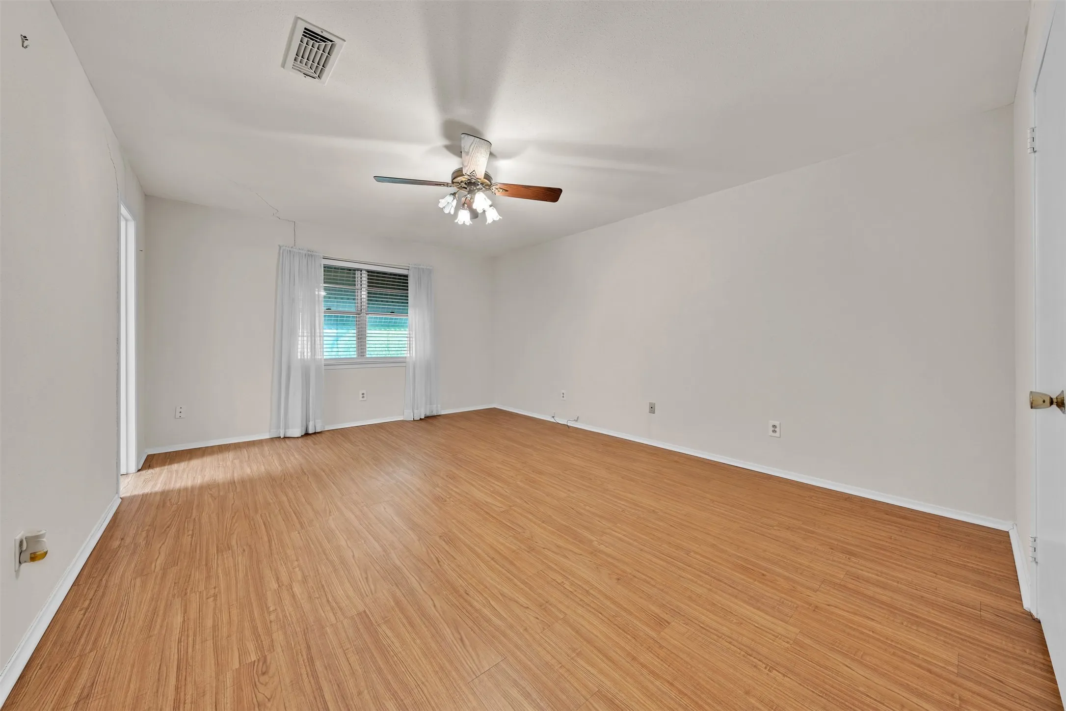 Spare room with light wood-type flooring and ceiling fan