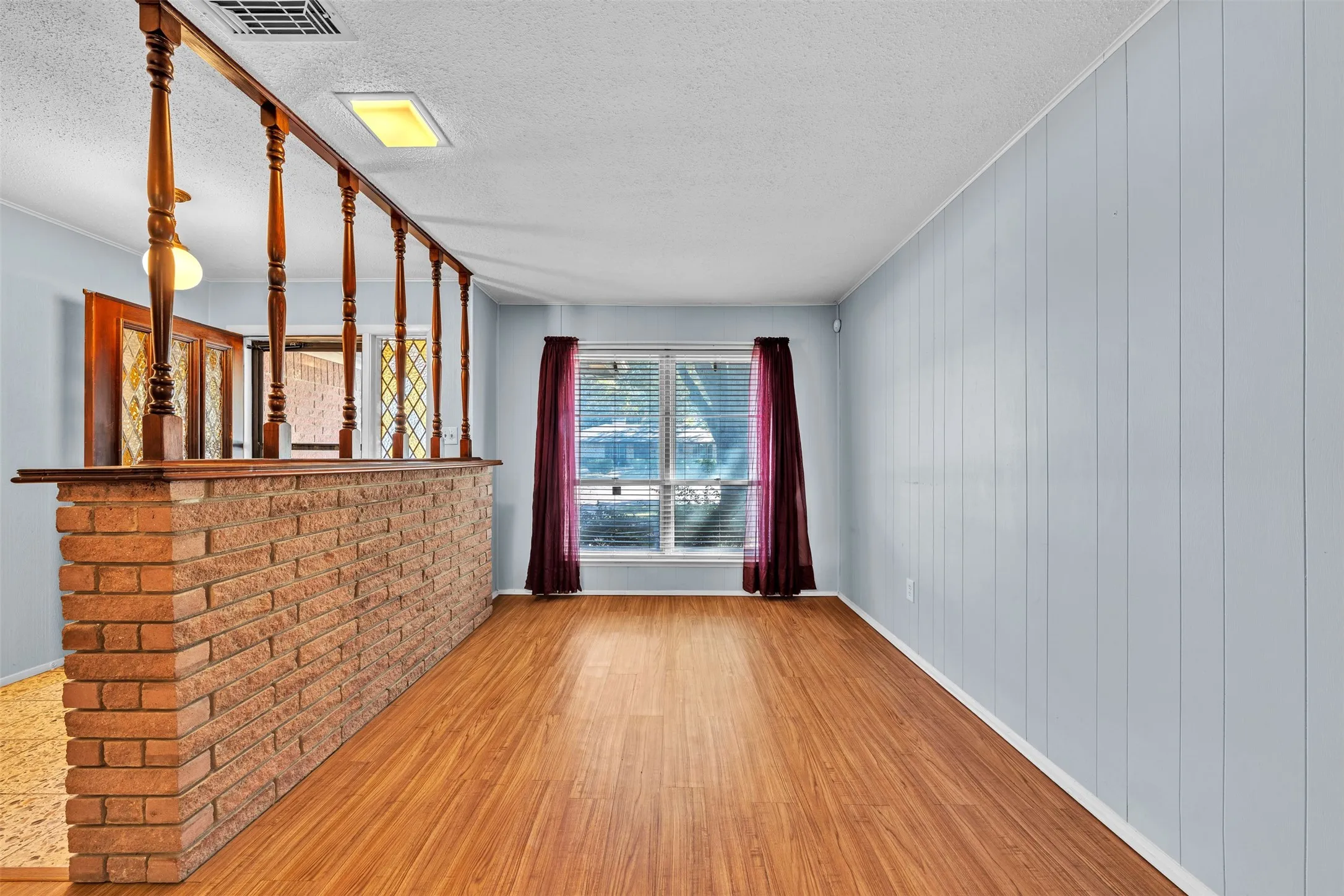Unfurnished room with a textured ceiling, wood finished floors, and ornamental molding