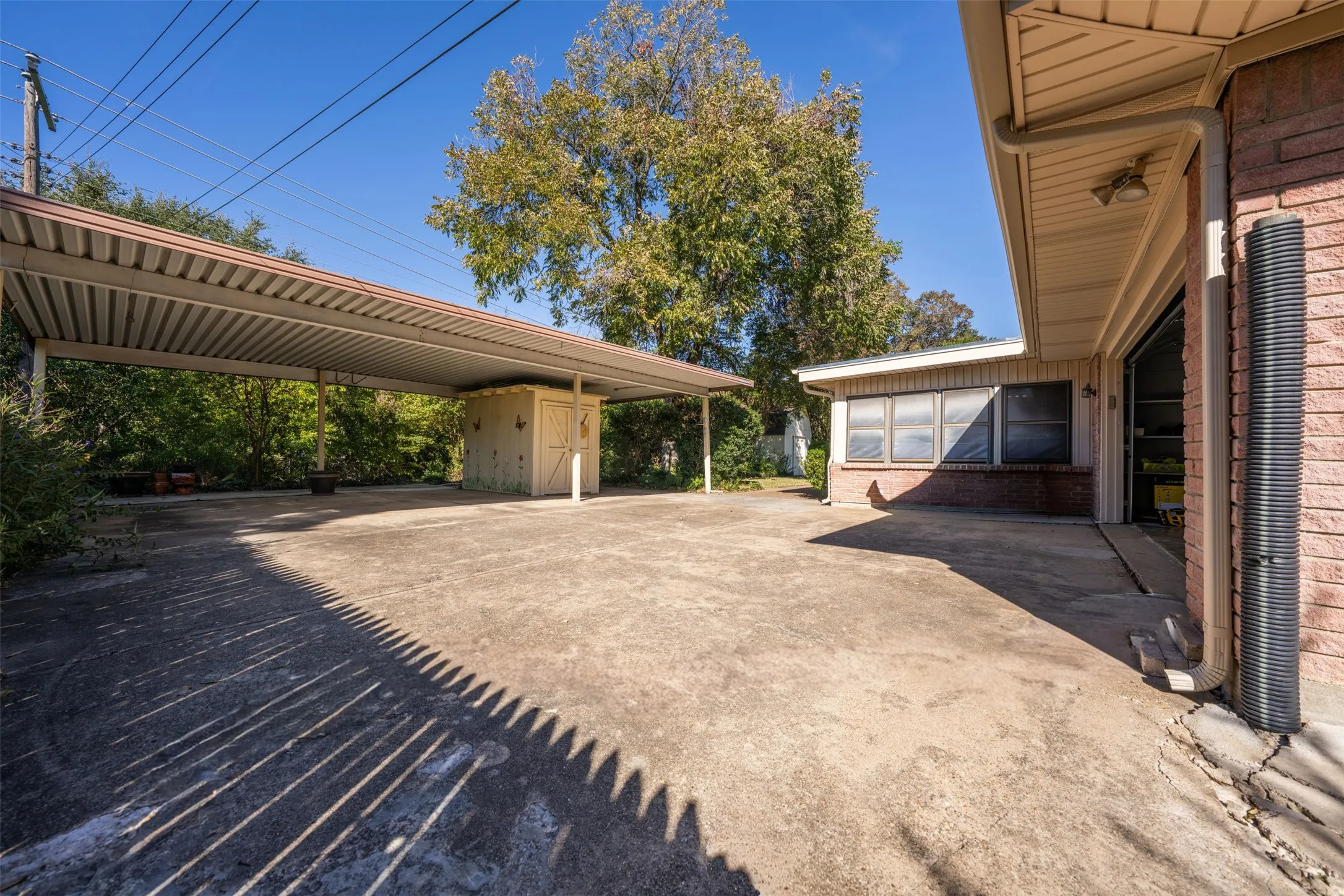 View of parking / parking lot with concrete driveway and a storage unit