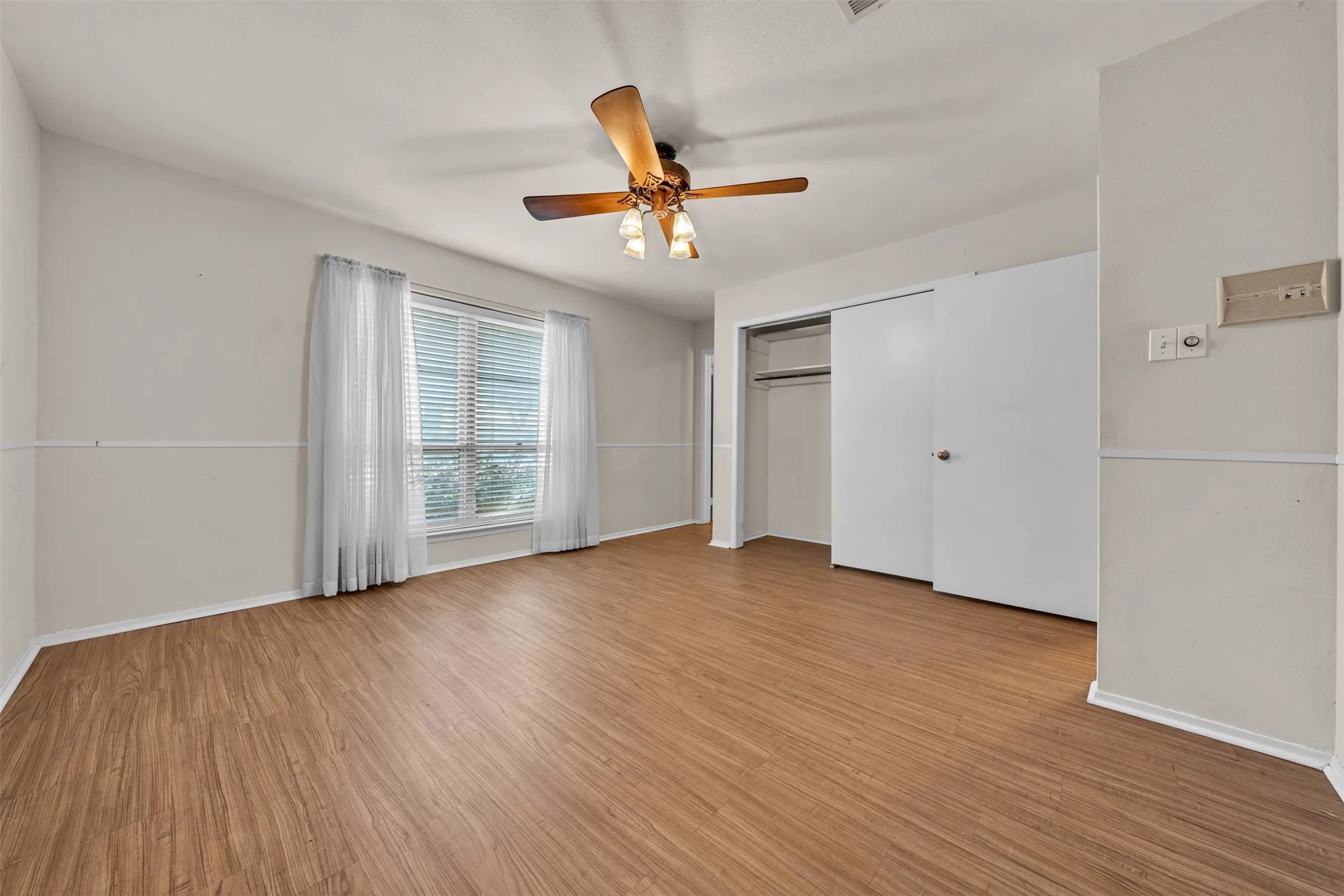 Unfurnished bedroom with light wood-type flooring, a ceiling fan, and a closet