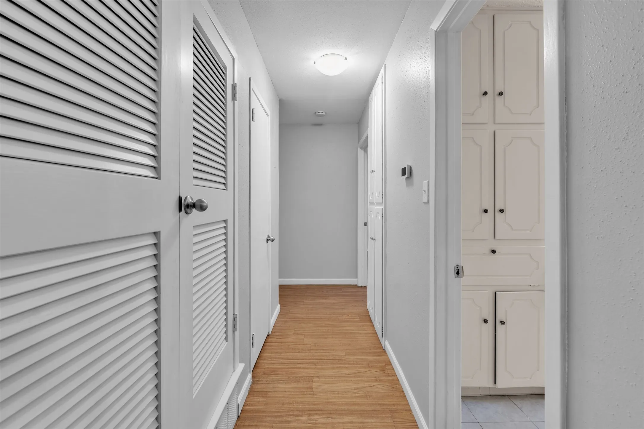 Hallway with baseboards and light wood finished floors