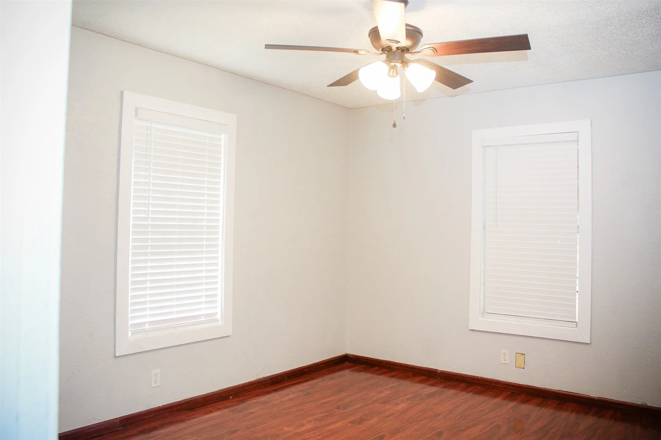 Unfurnished bedroom room 1 featuring wood-type flooring and ceiling fan