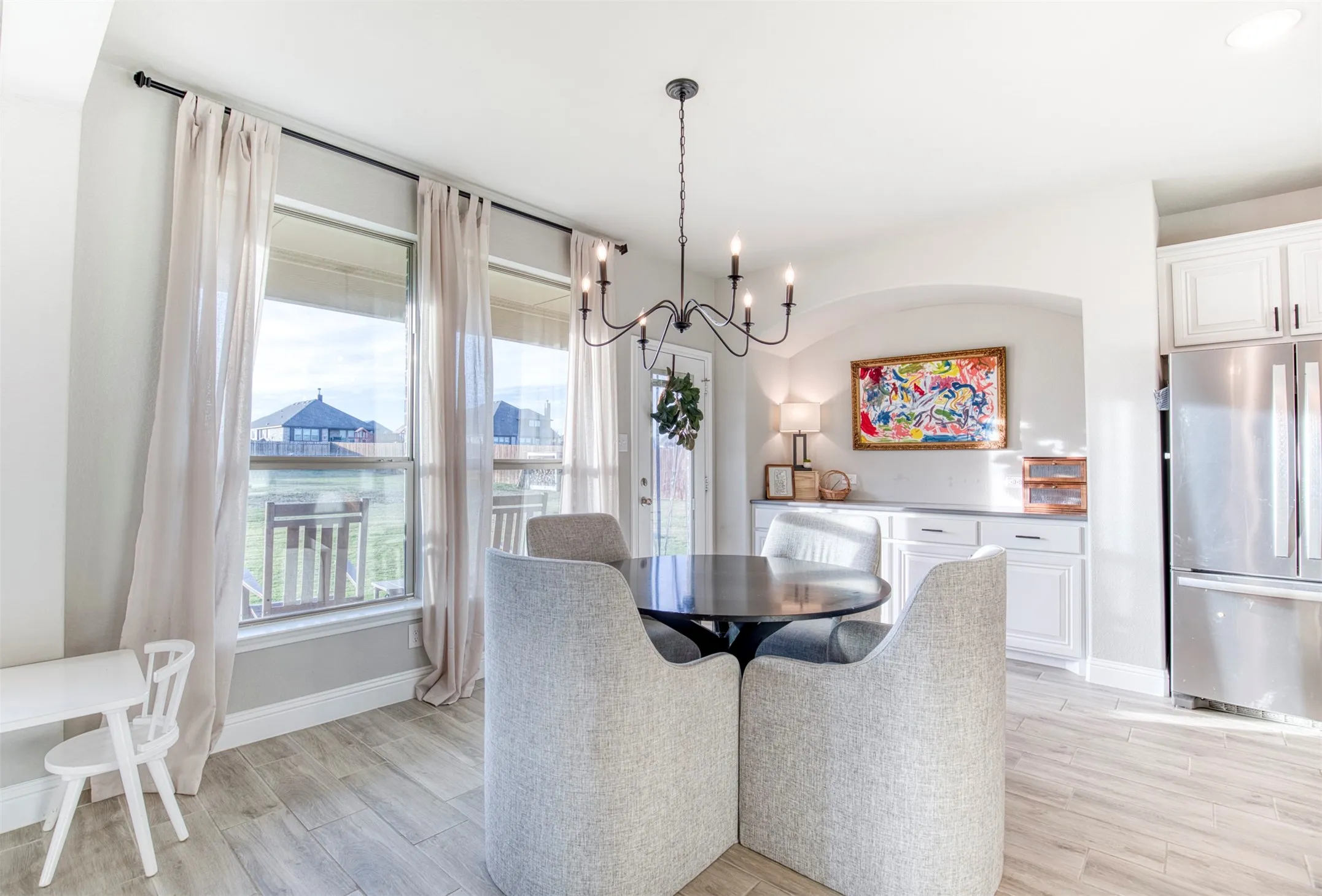 Dining room with custom cabinetry in nook, chandelier, and stunning view of backyard.