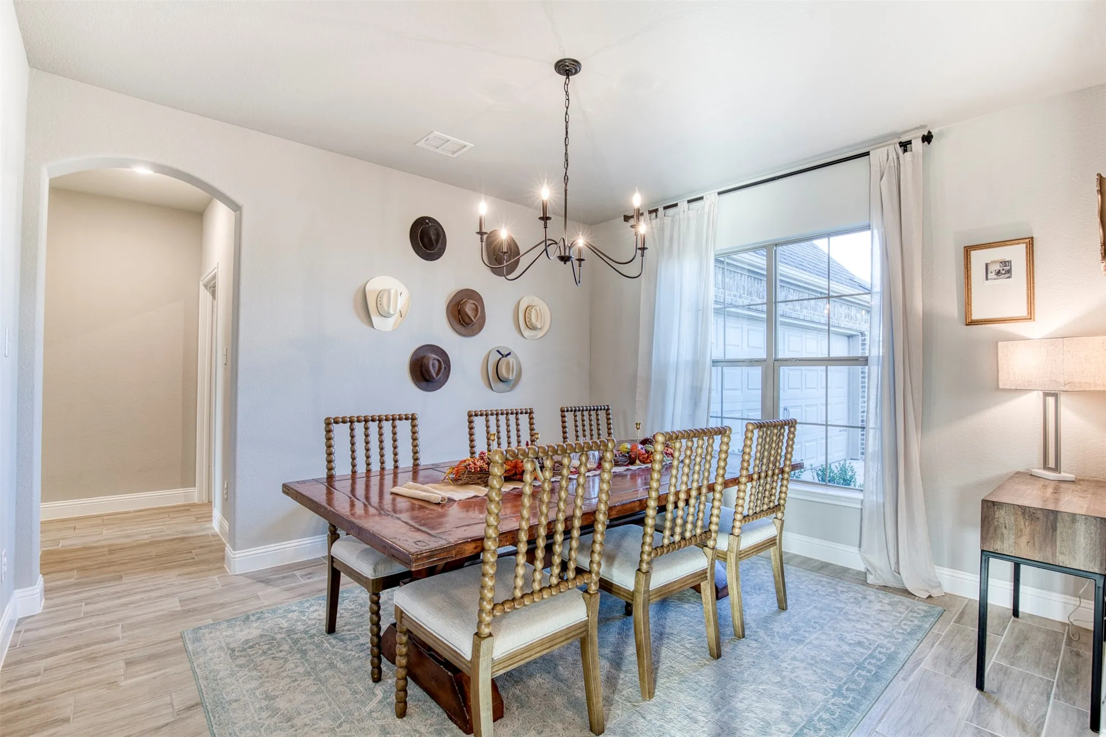 Dining room with luxury vinyl plank flooring, chandelier, and natural light.