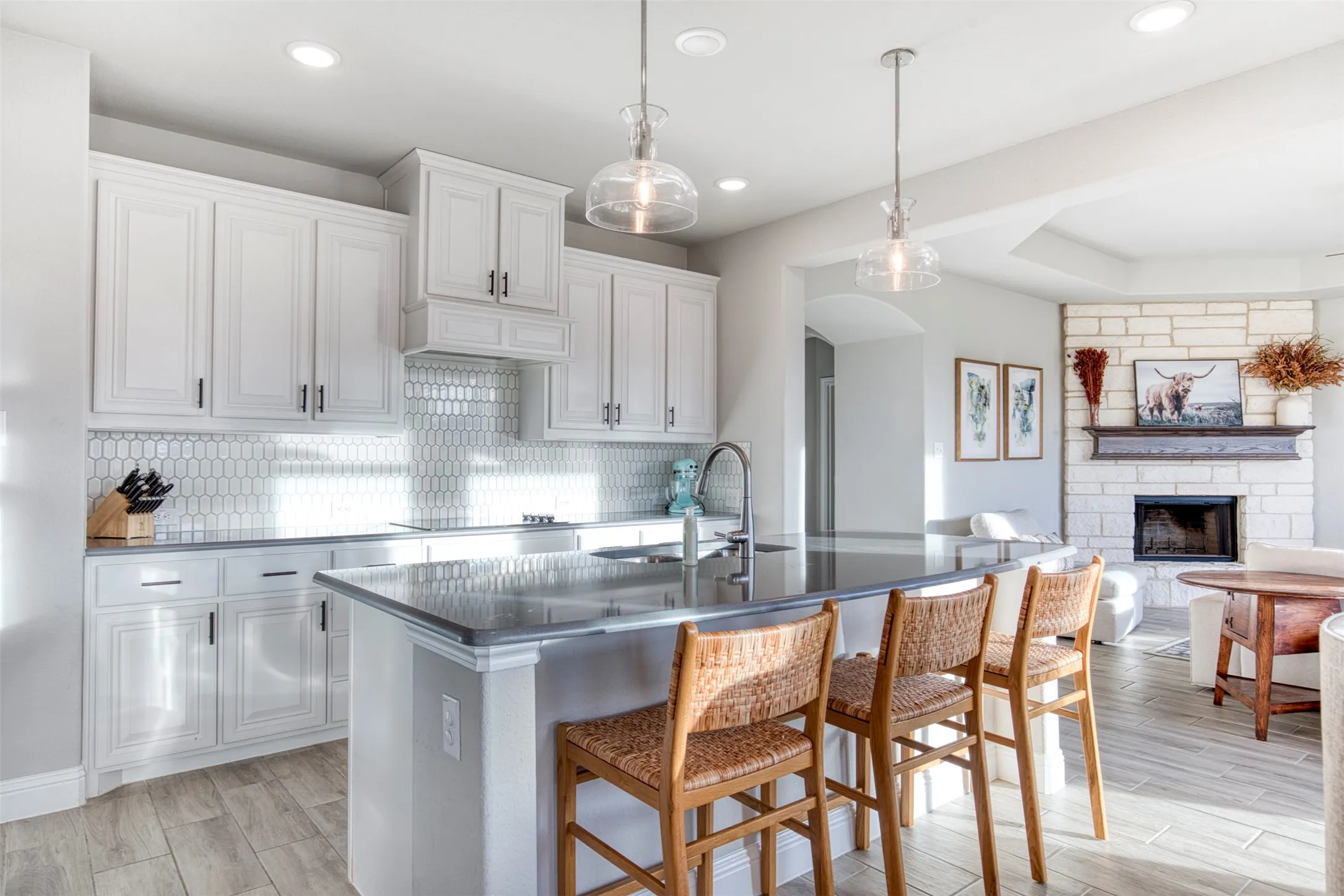 Gourmet kitchen with pristine white cabinetry and designer backsplash.