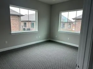Carpeted empty room featuring baseboards