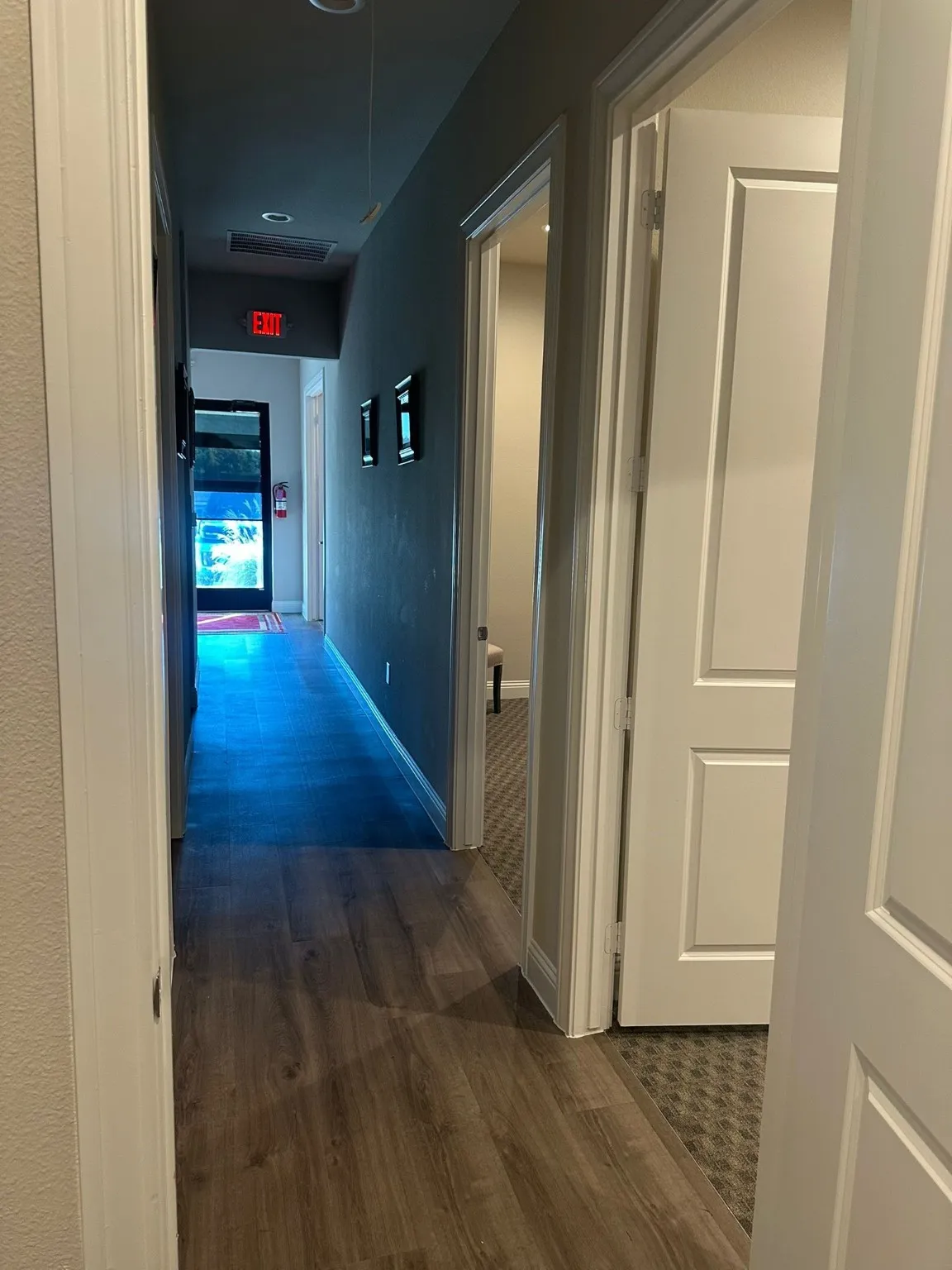 Hall featuring dark wood-style flooring and baseboards