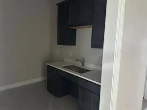 Kitchen with light countertops and dark cabinetry