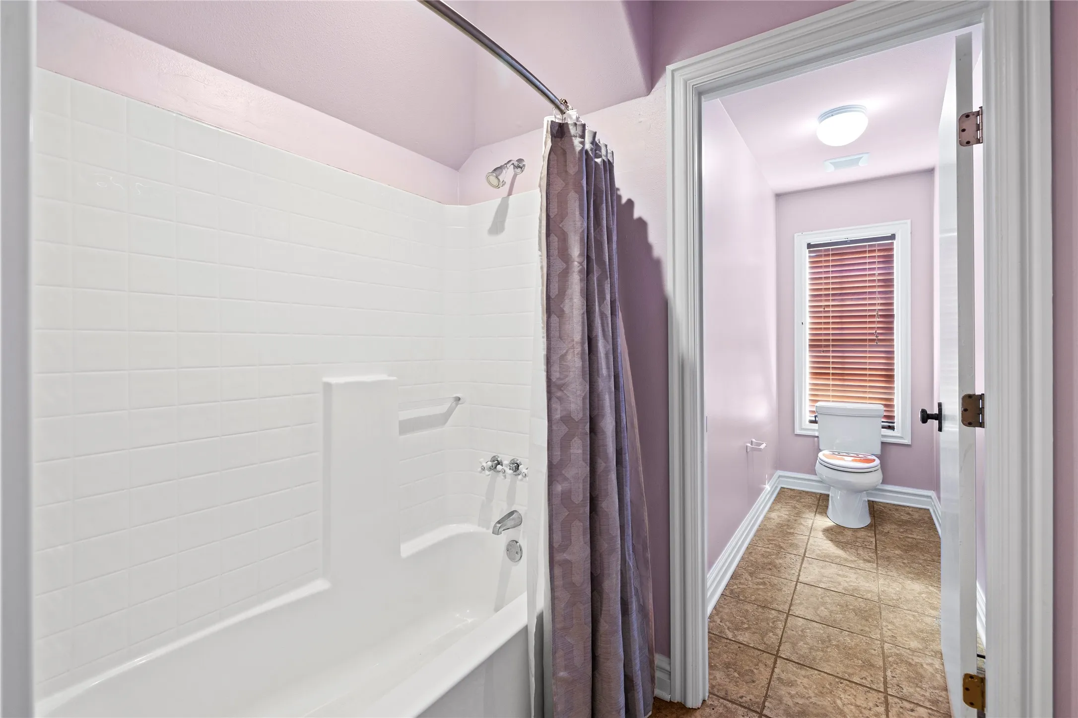 Full bath featuring shower / bath combo with shower curtain and tile patterned flooring