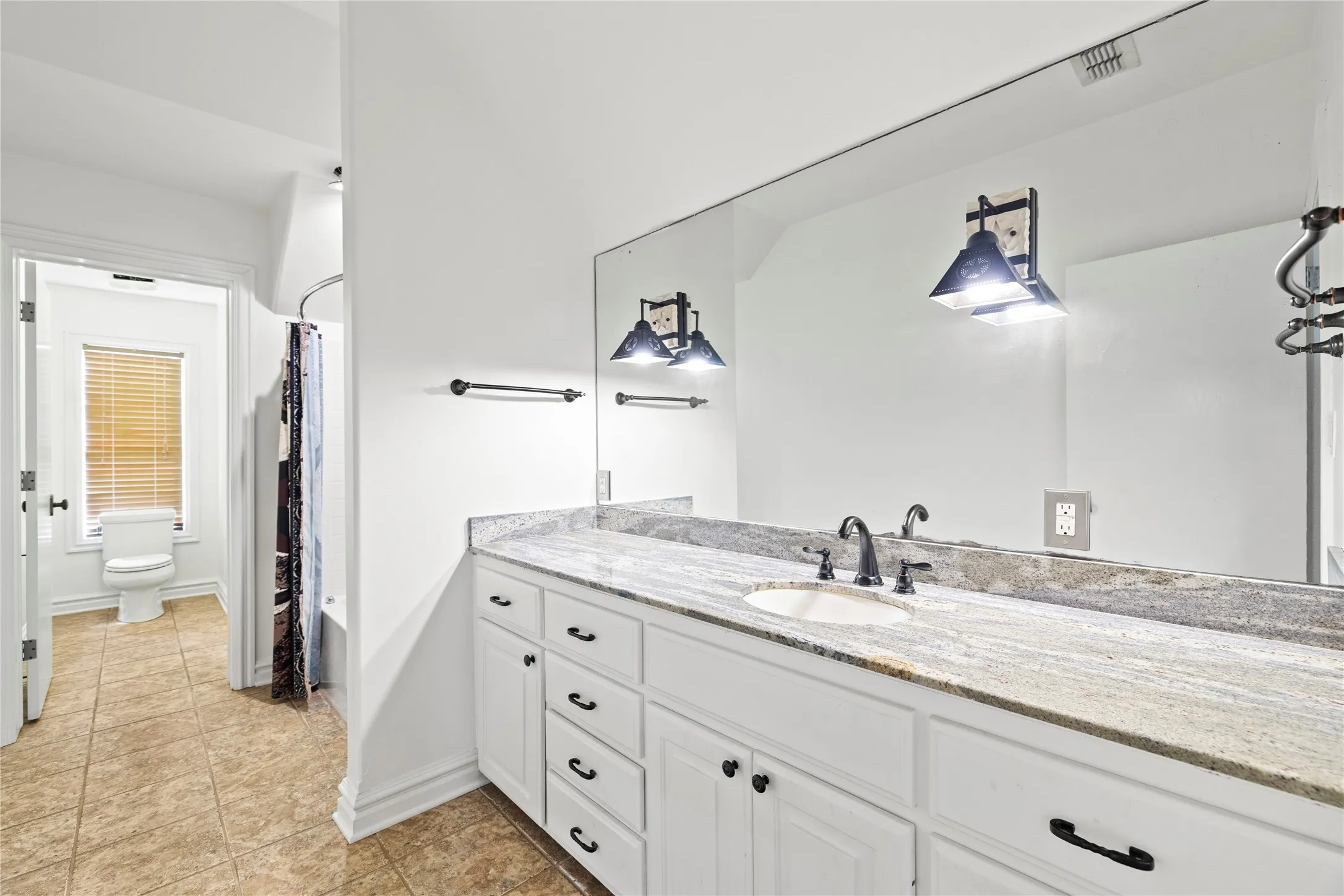 Full bathroom featuring shower / tub combo, vanity, and light tile patterned floors