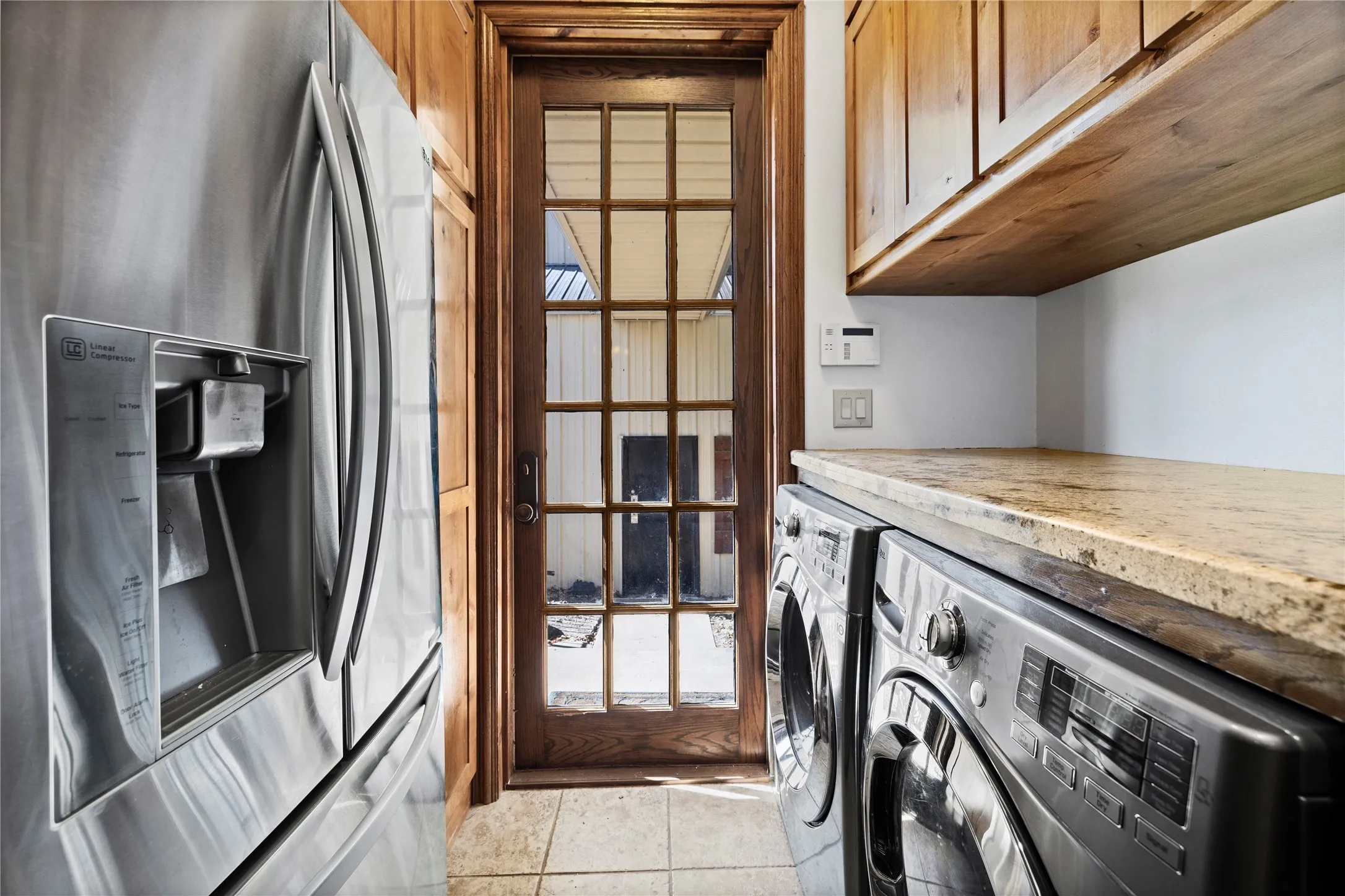 Washroom with light tile patterned flooring, cabinet space, and washing machine and dryer
