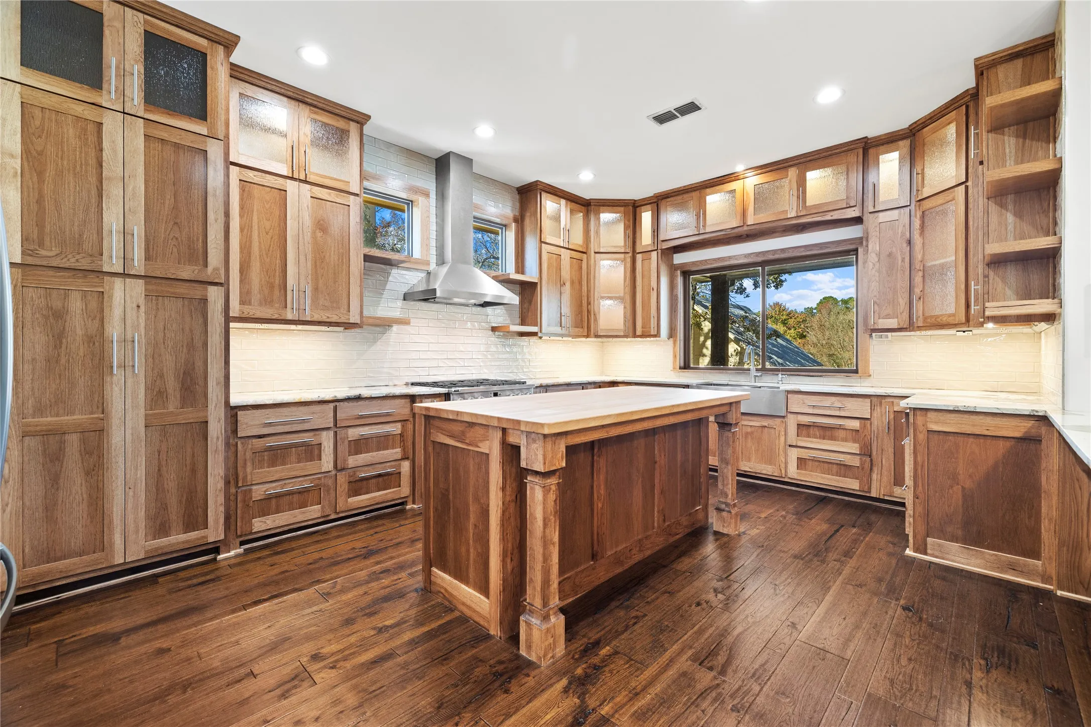 Kitchen featuring open shelves, brown cabinetry, backsplash, and recessed lighting